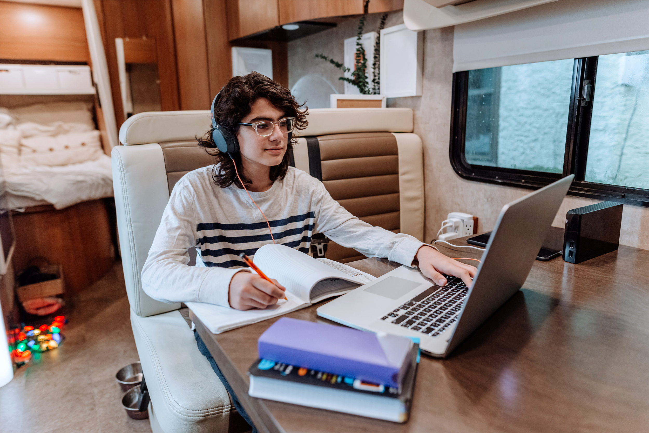 boy doing homework in an RV on a laptop
