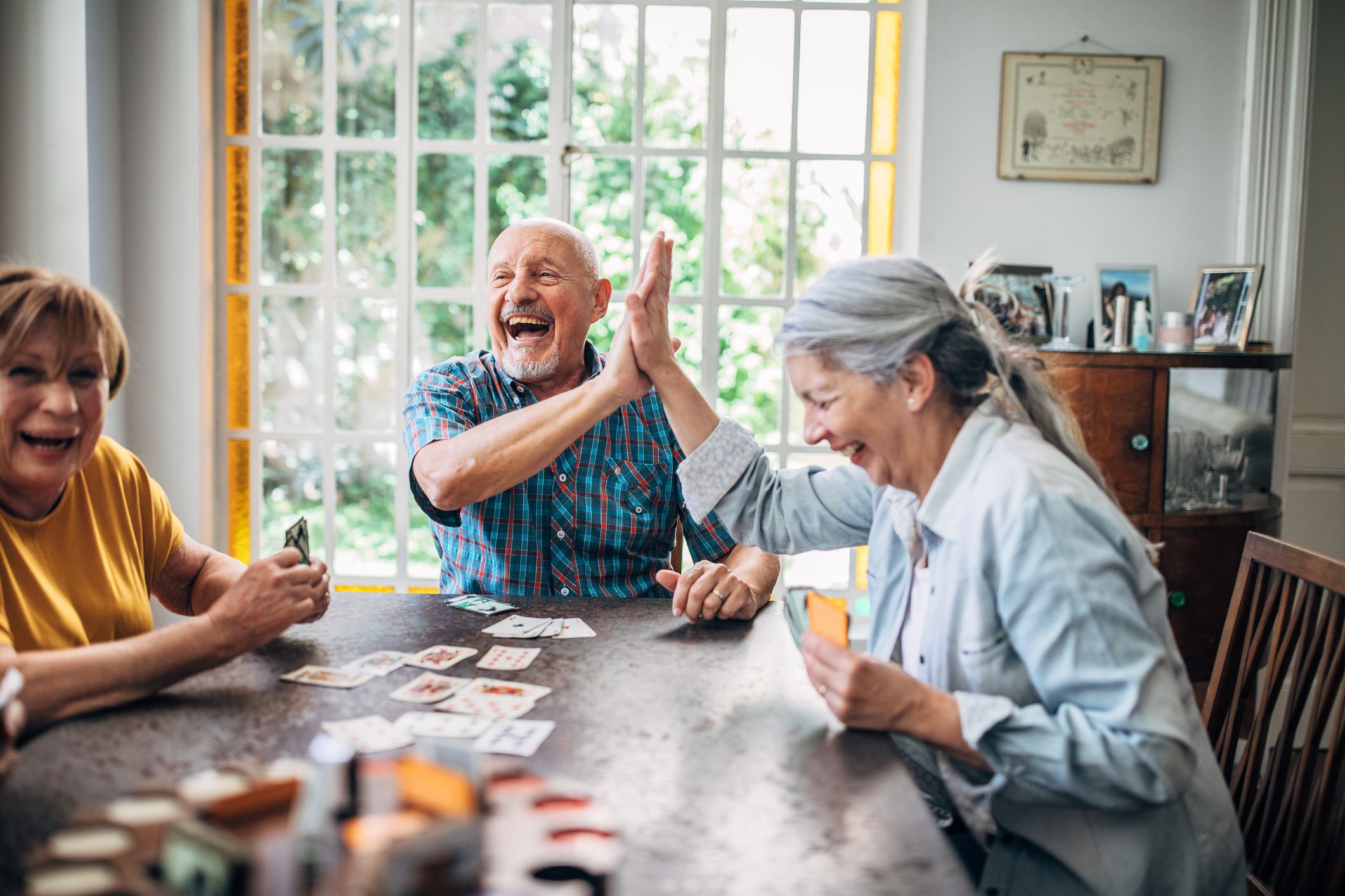 Group of people, senior people playing cards in nursing home.