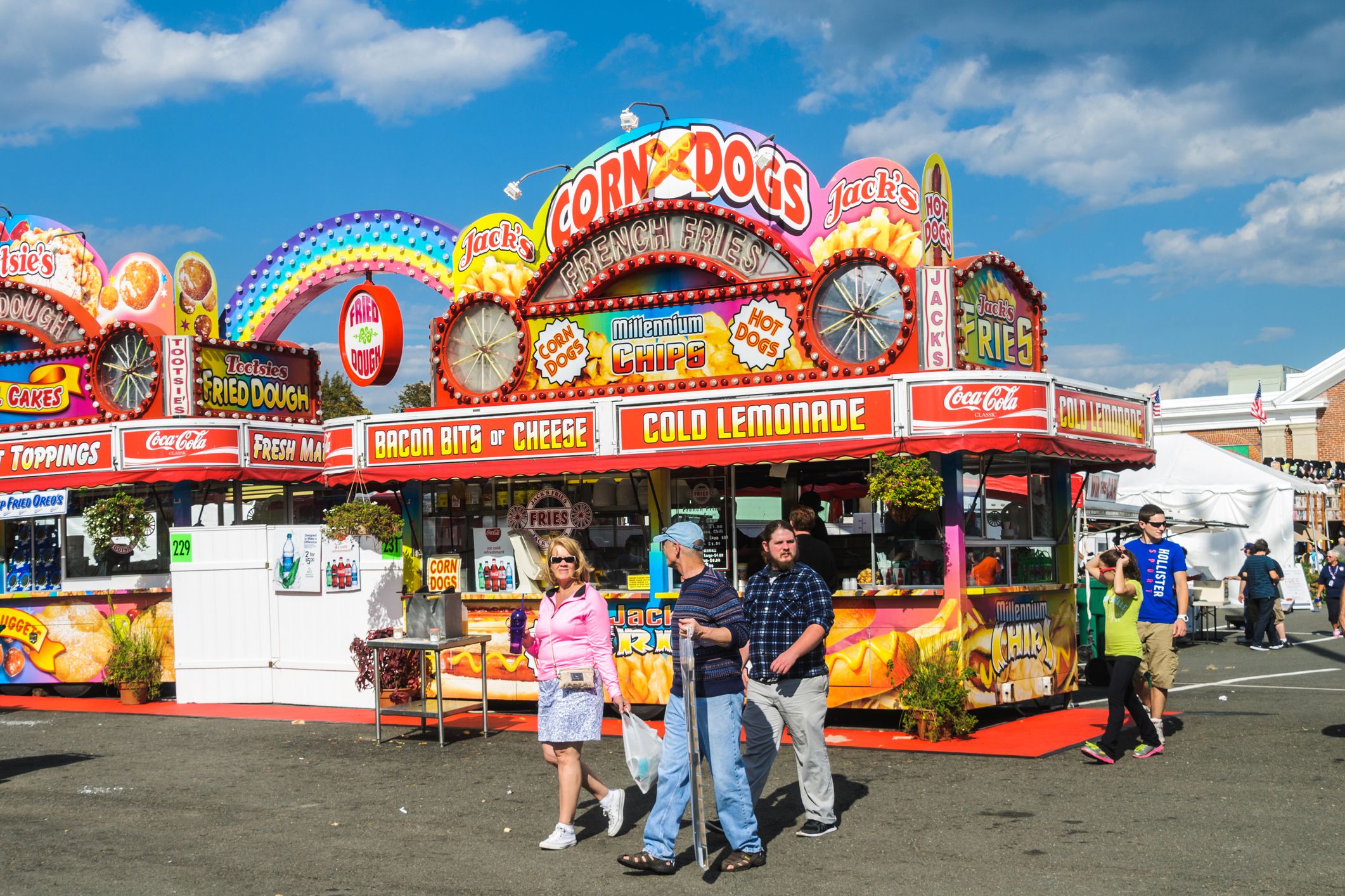West Springfield, Massachusetts, USA - September 18, 2014: Fairgoers stroll past a colorful food concession at the Eastern States Exposition. With dozens of food venues throughout the fairgrounds, bright displays are required to attract customers