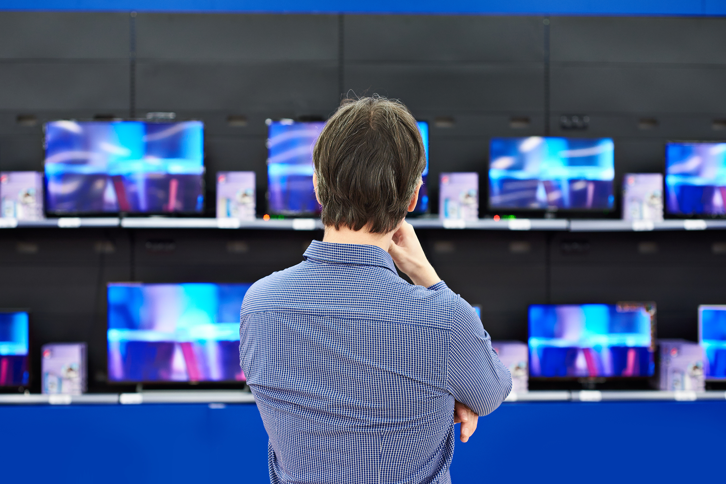 Man looking at televisions in a store