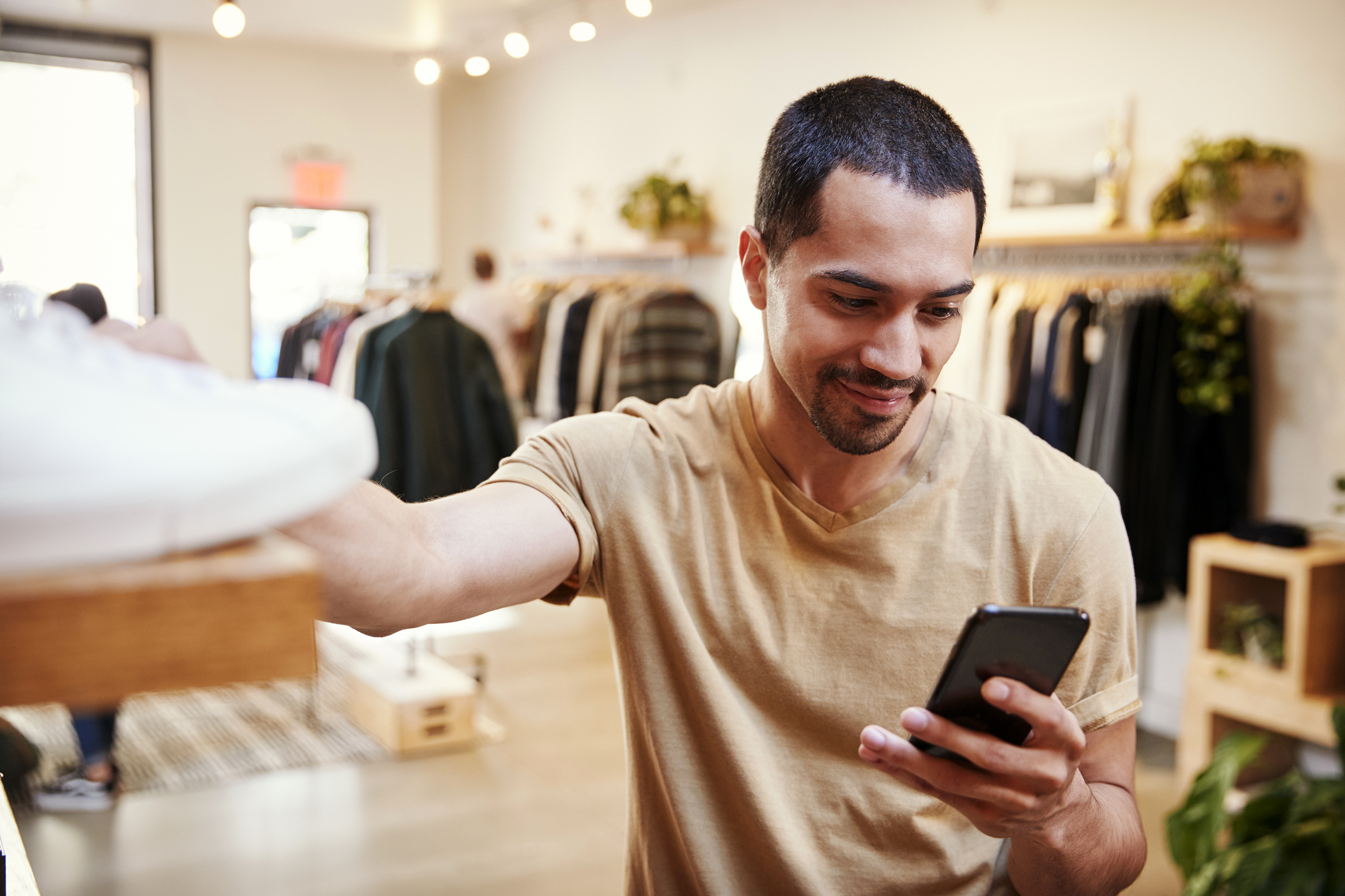 Man looking at his phone while shopping
