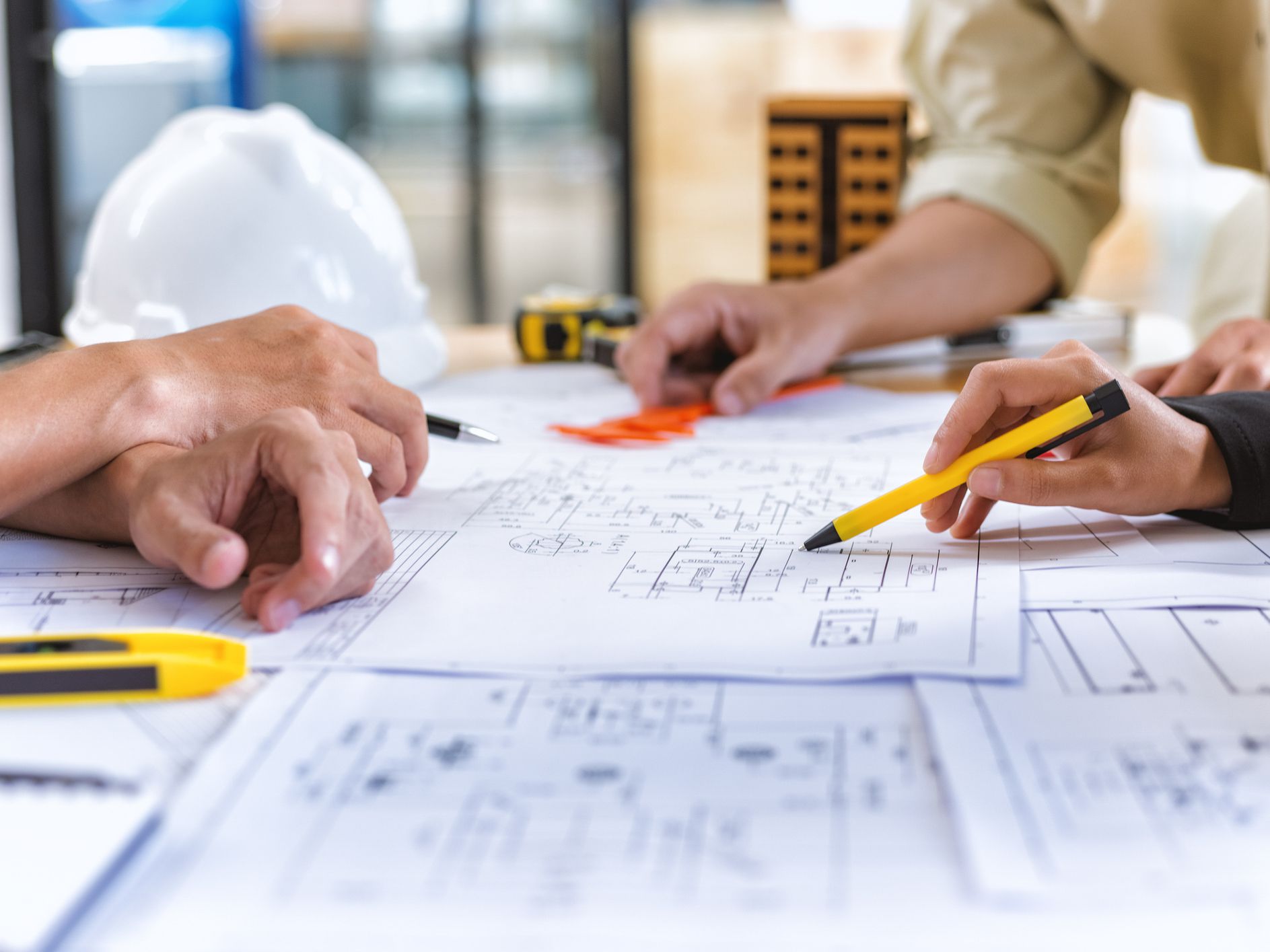 Image of team engineer checks construction blueprints on new project with engineering tools at desk in office.