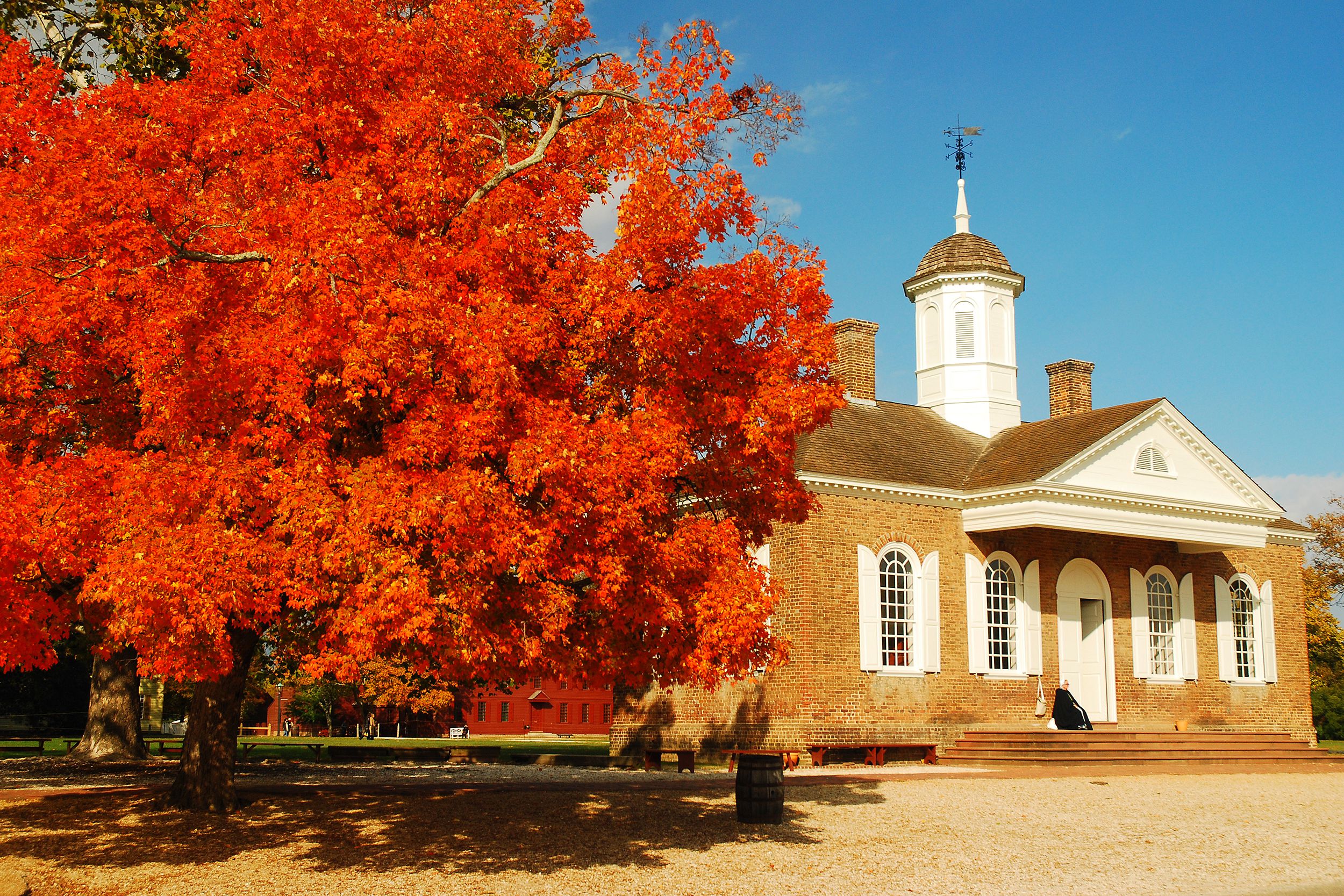 Bright red autumn tree in front of an old building