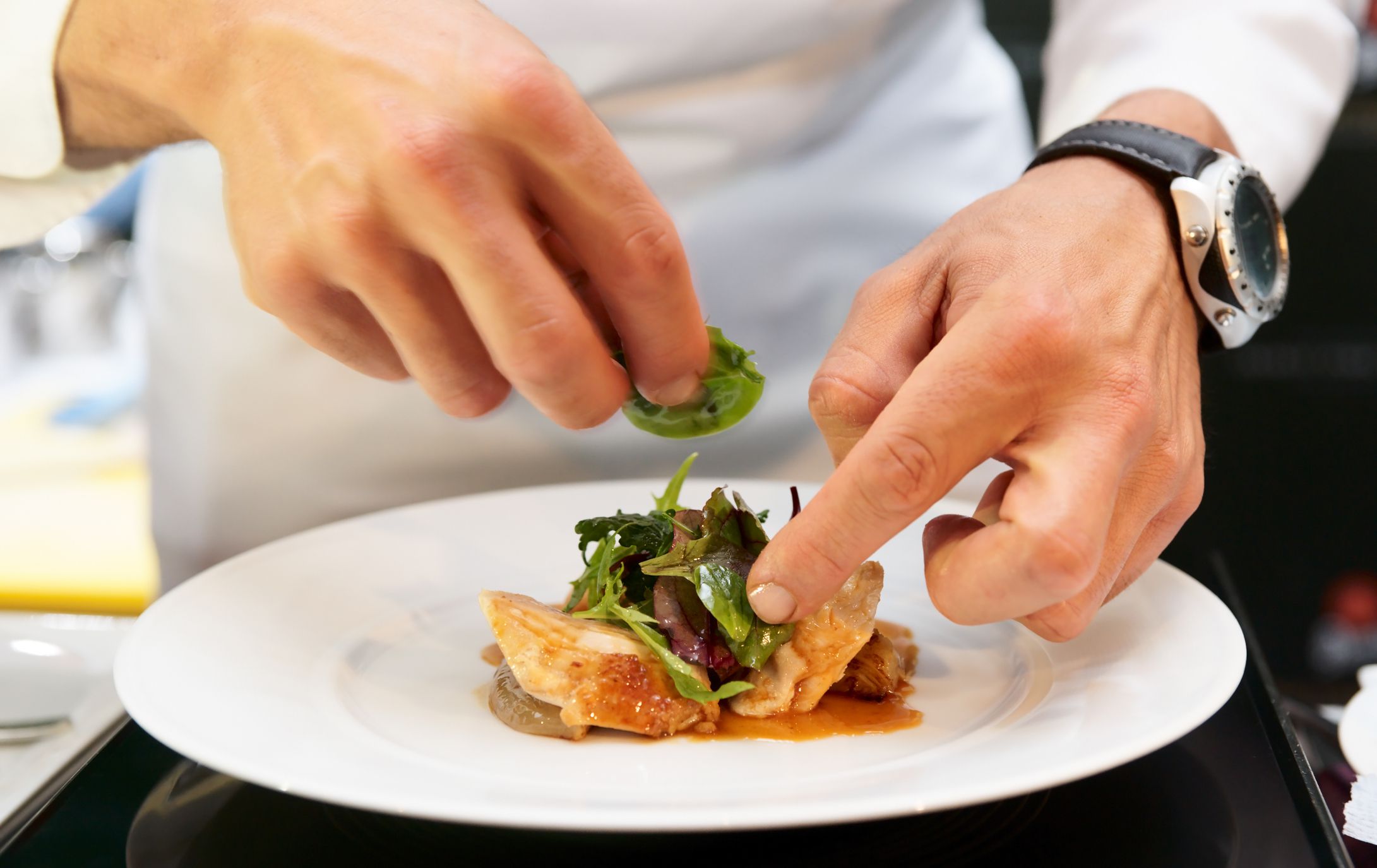 Chef is decorating delicious dish, motion blur on hands