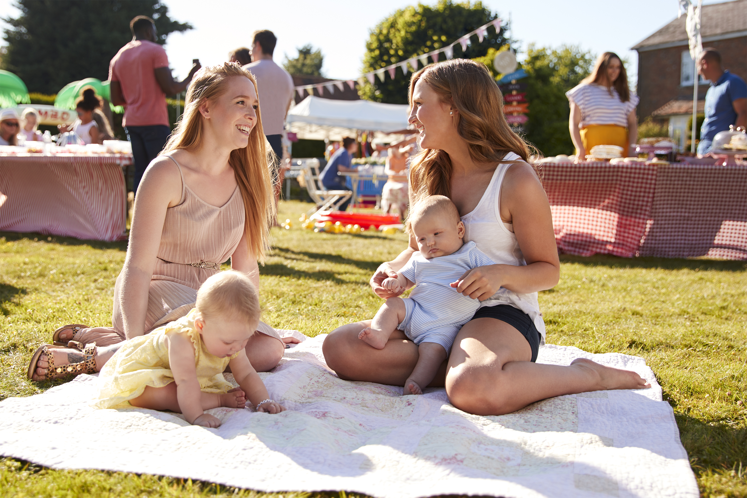 Young mom friends sitting and talking with their babies