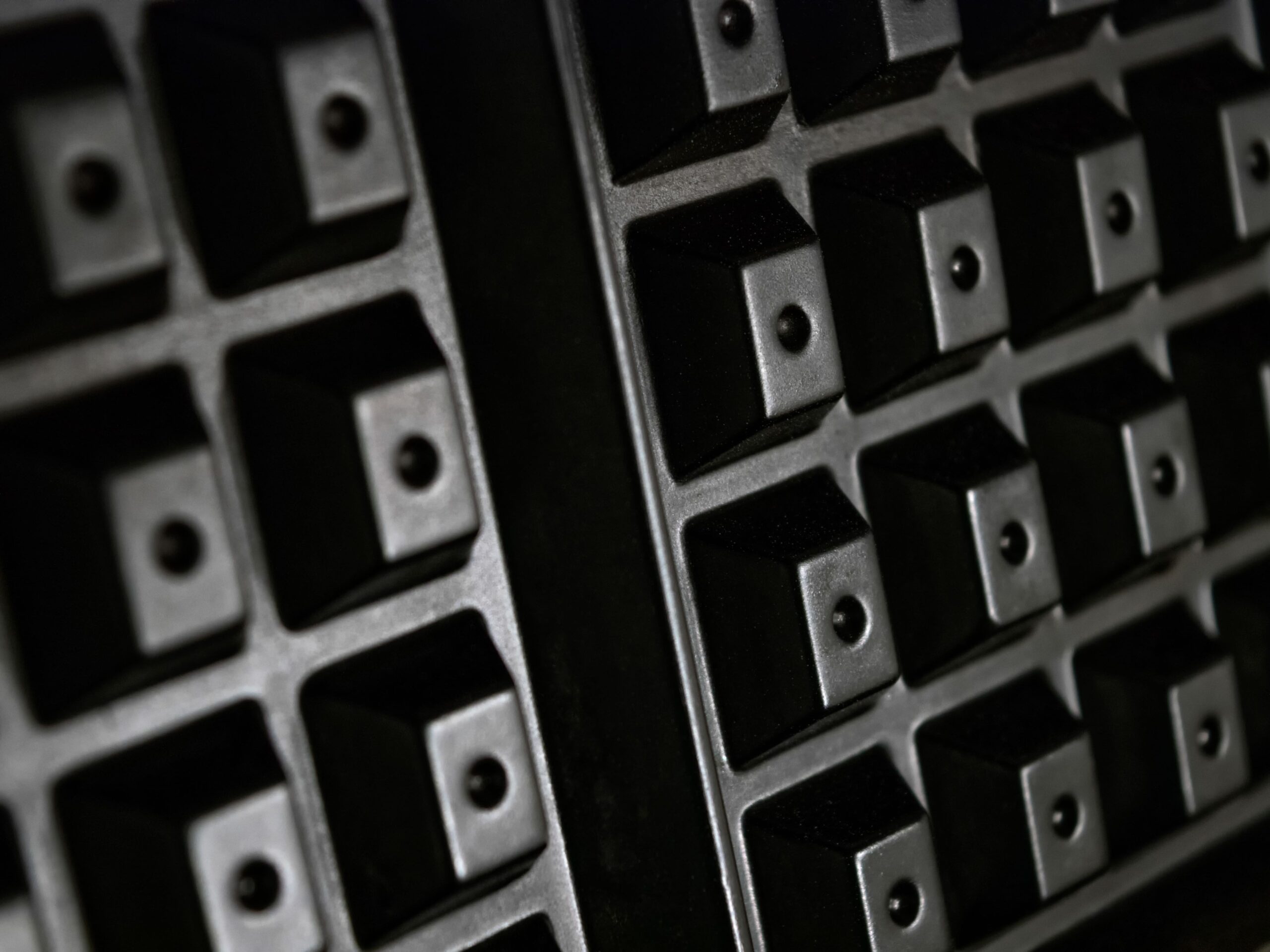 An abstract close-up of a black waffle irons square pattern. This cooking appliance is used to make Belgiam Waffles in the USA, which area lighter and fluffier with larger squares that make for deeper pockets in the waffles.
