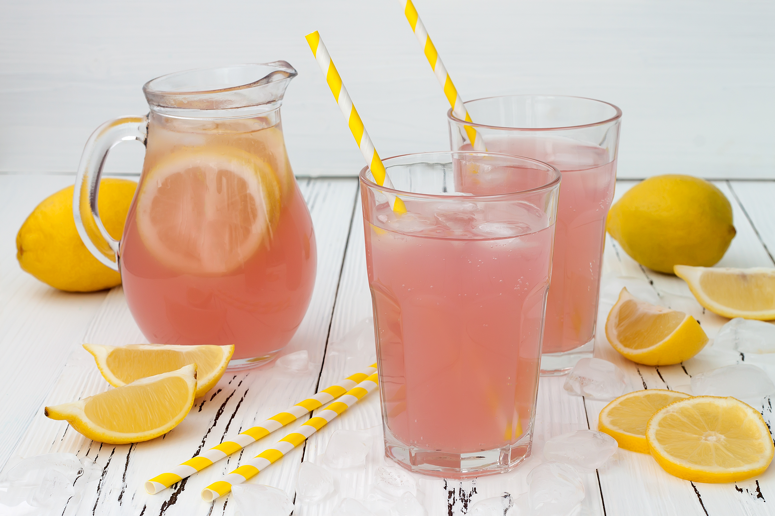 Glass pitcher and glasses of pink lemonade