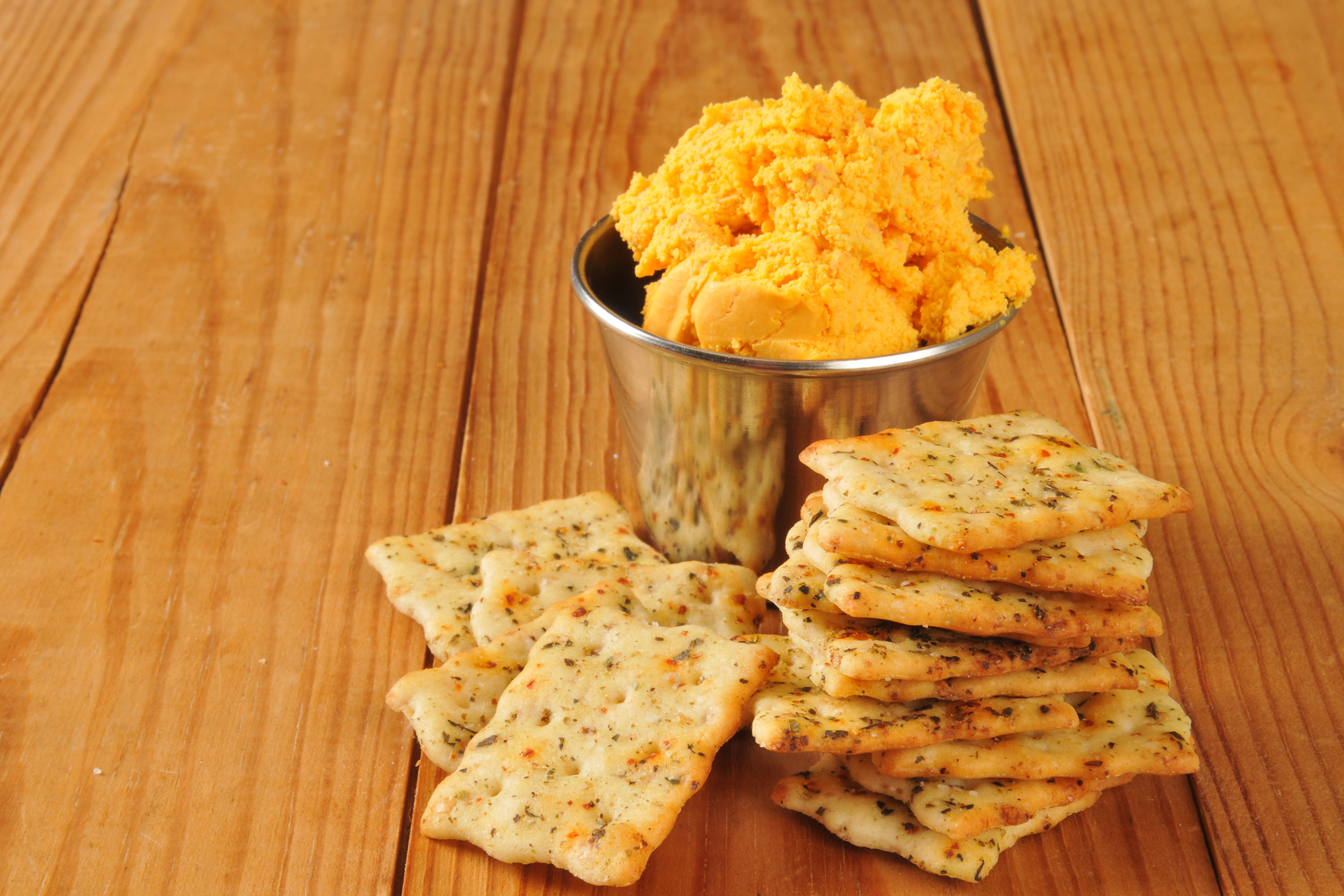 Cheese spread in a small cup with crackers