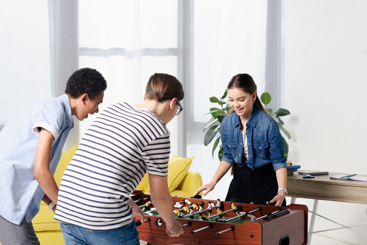 teens playing foosball