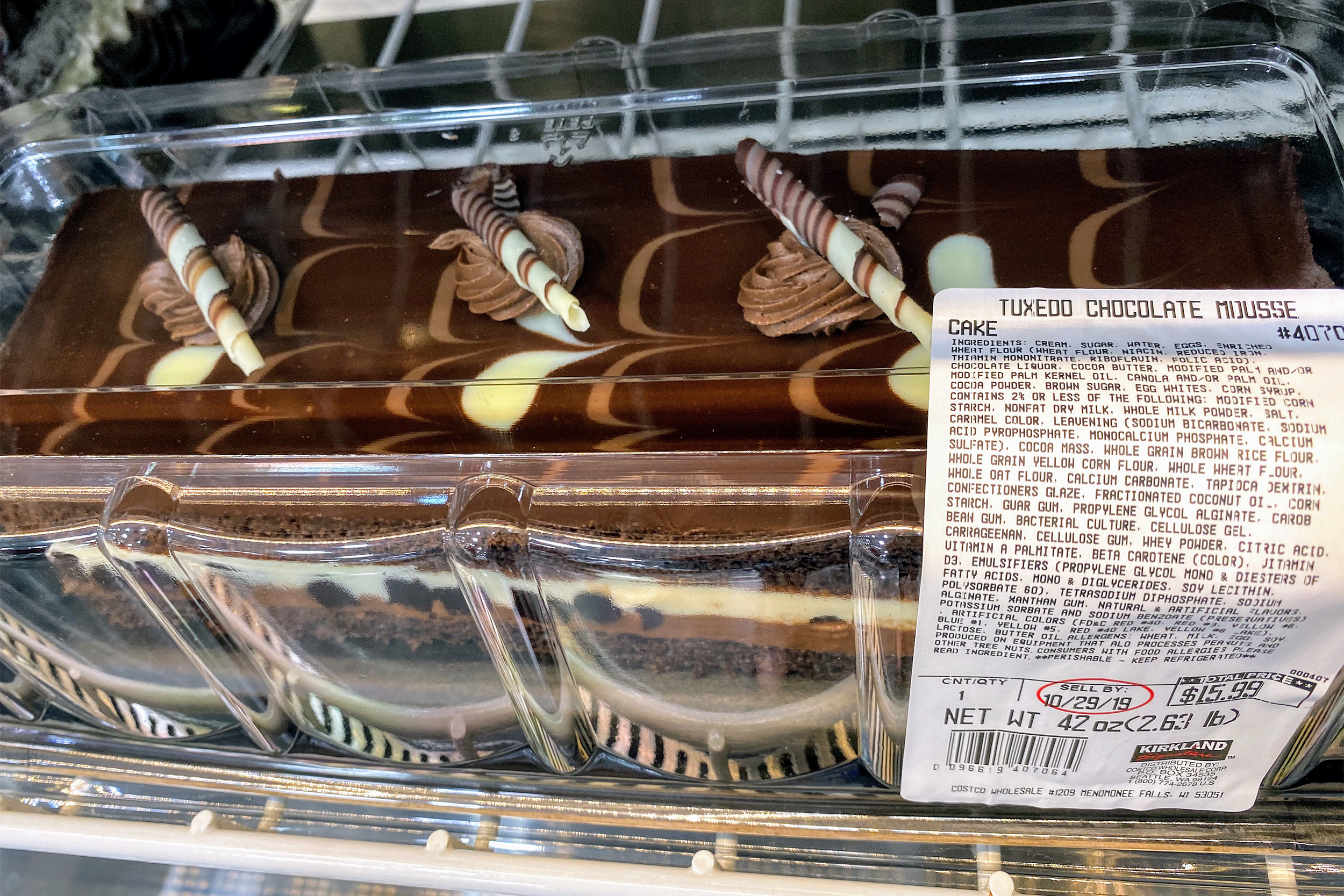 Closeup of Kirkland Tuxedo Chocolate Mousse Cake at a Costco in a refrigerator, another cake on the top left