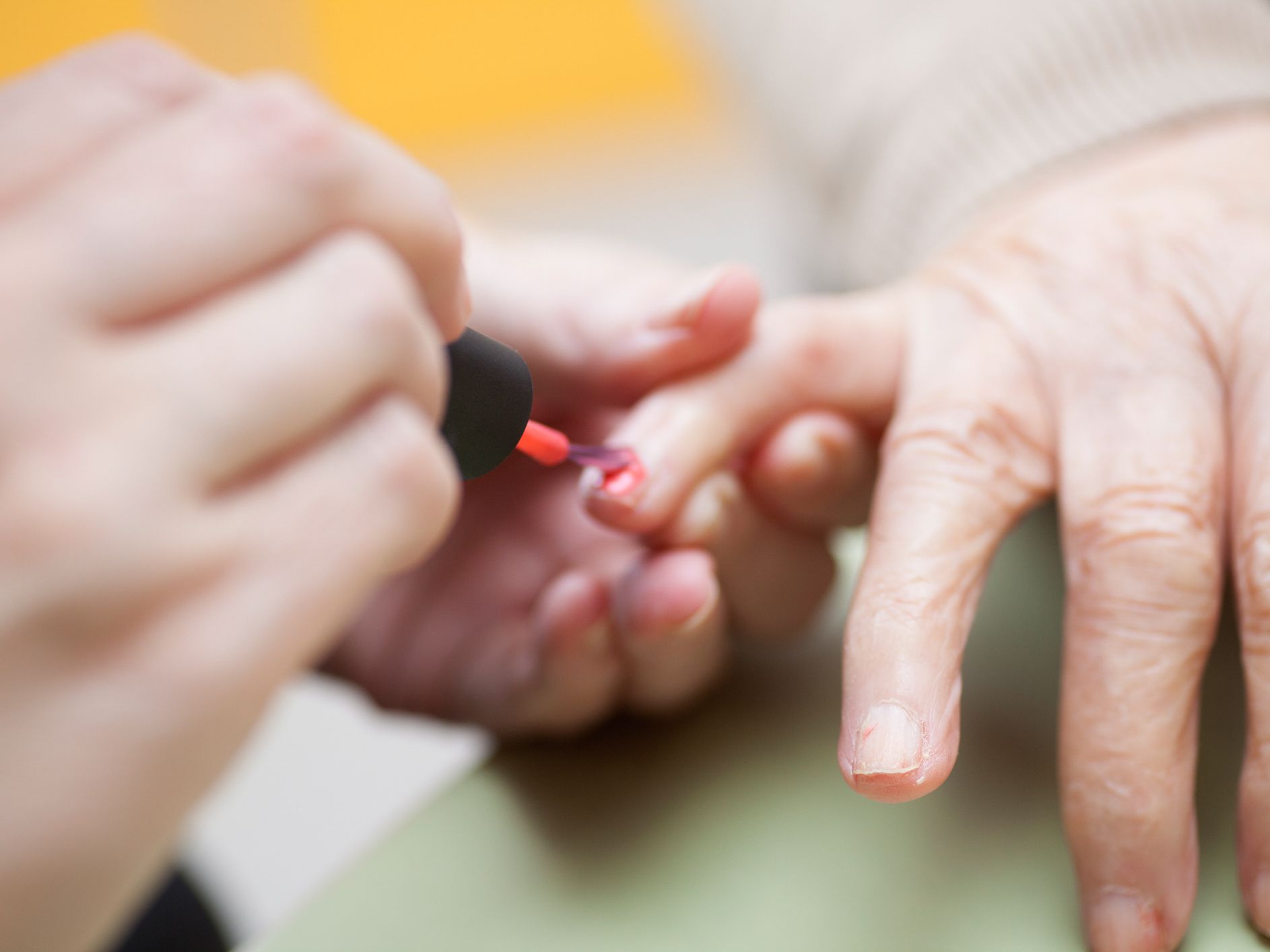 Woman doing manicure to her old mother