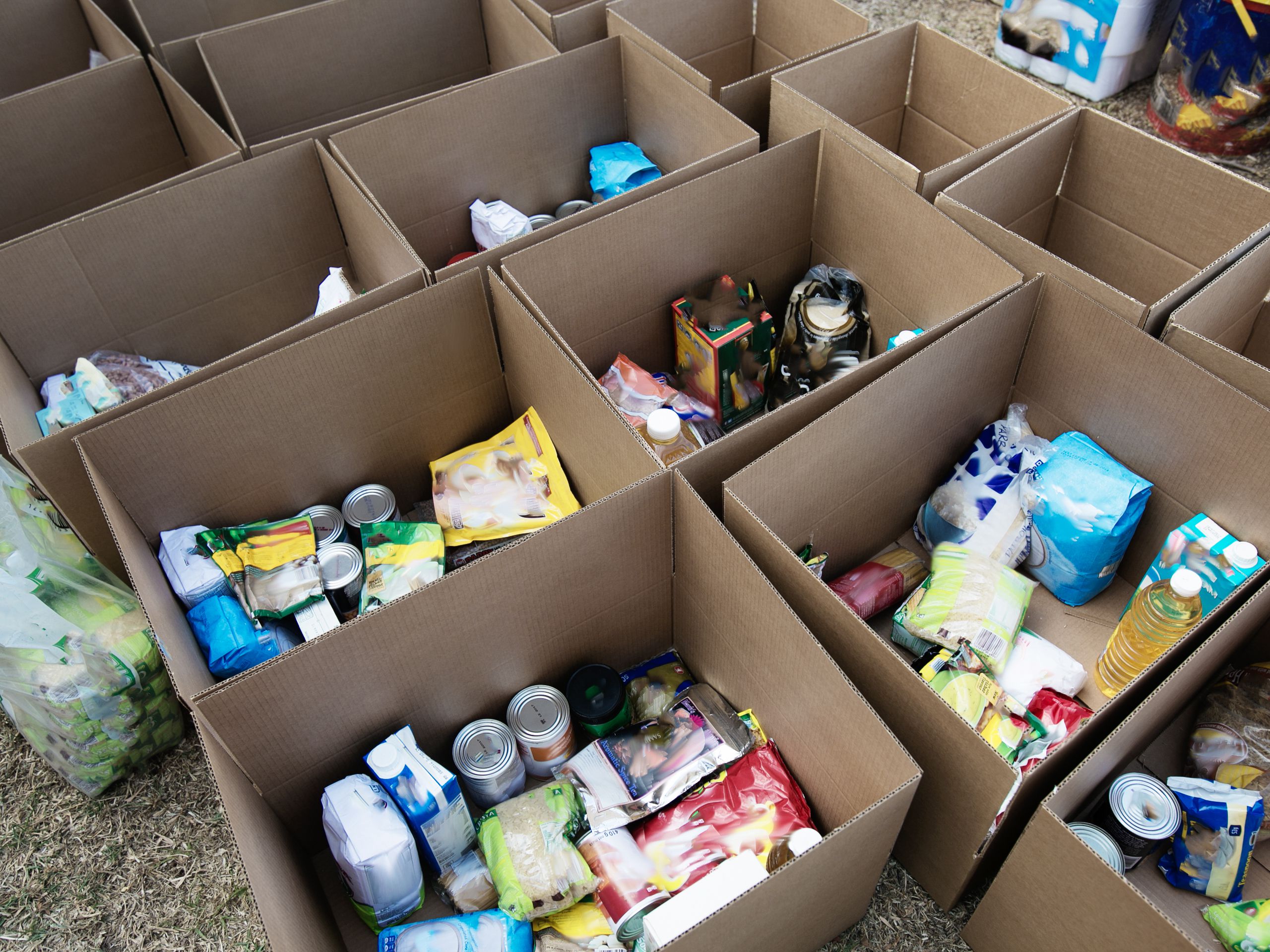 Cardboard boxes being filled with food donations for Coronavirus disaster relief.