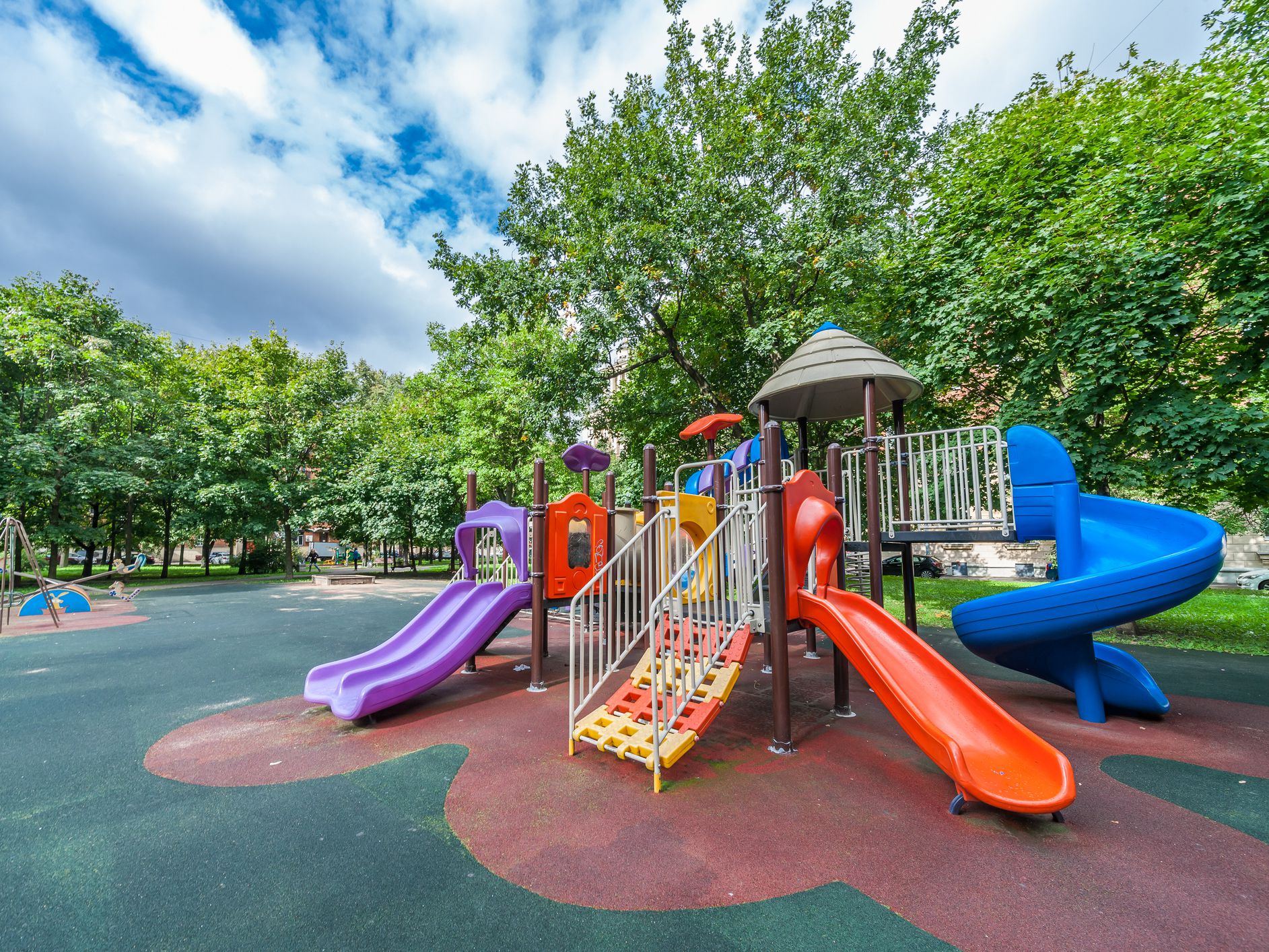 Colorful playground equipment for children in public park in summer