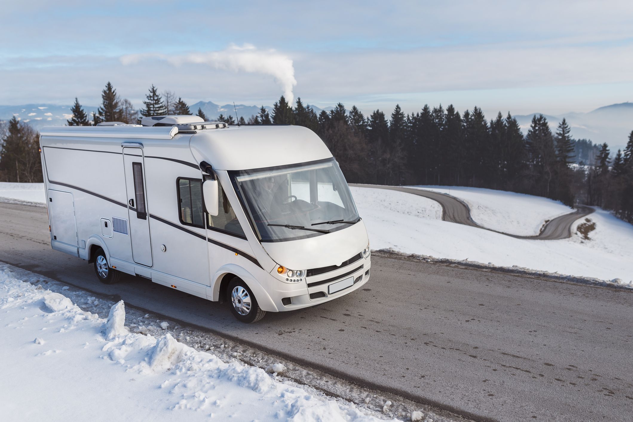 Young guy driving a luxury caravan in the winter
