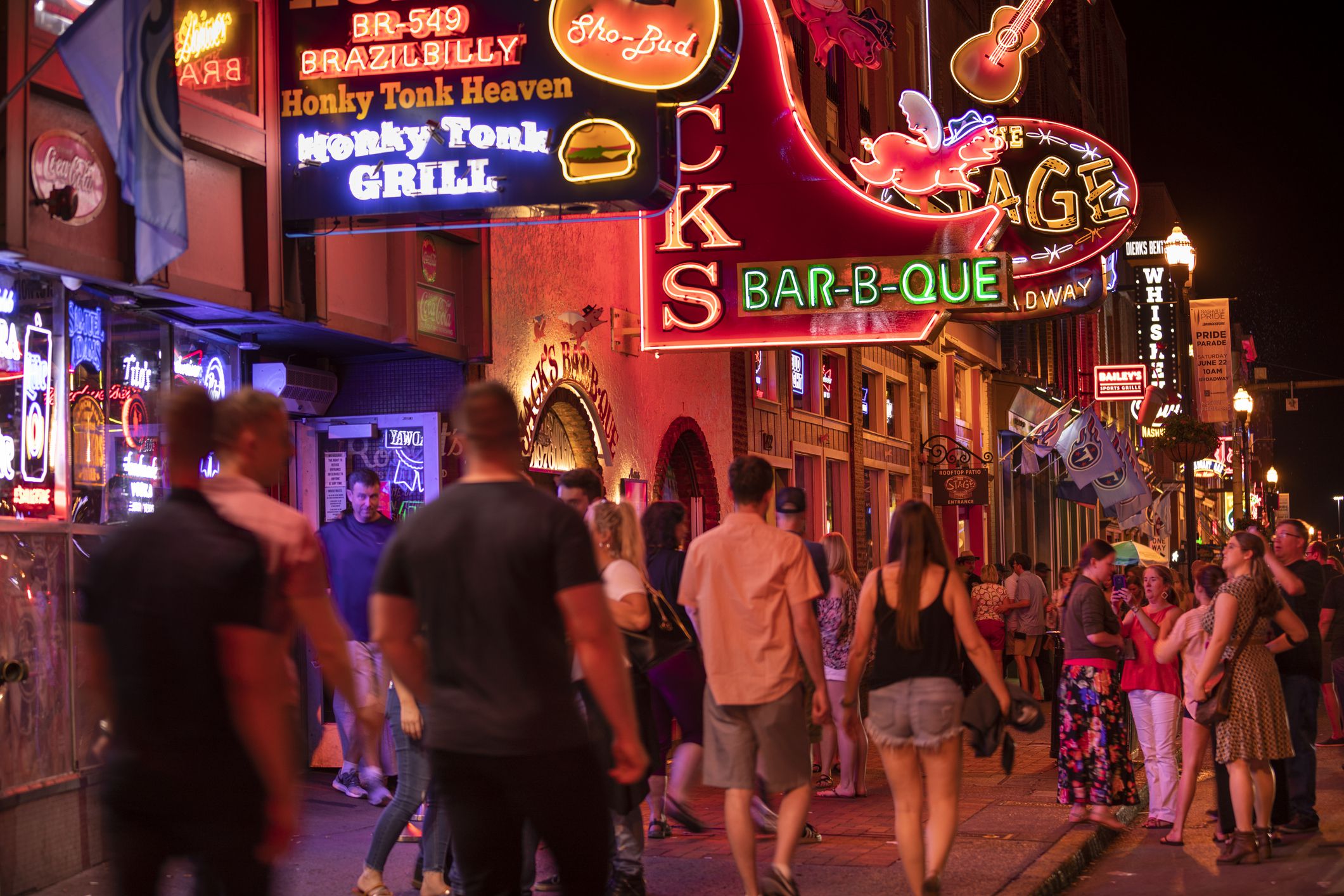 Nashville, Tennessee - June 20, 2019: Colorful neon store signs hang along the bars restaurants and record stores along Broadway Street in downtown Nashville Tennessee USA