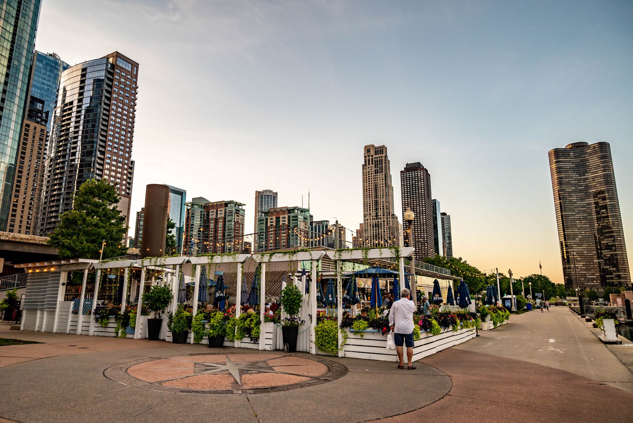 Chicago, IL - August 15, 2021: A man waits for a table to eat outdoors on a patio at DuSable Harbor, downtown in the Loop.