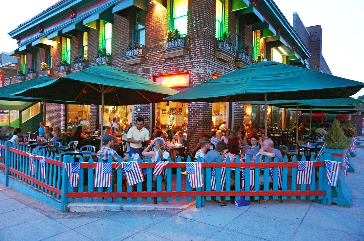 These diners are dining at a neighborhood Mexican restaurant in Cleveland Park in Northwest Washington DC after the fourth of July on a Monday night. American flags adorn the fence and these people are extending their fourth of July weekend by dining out.