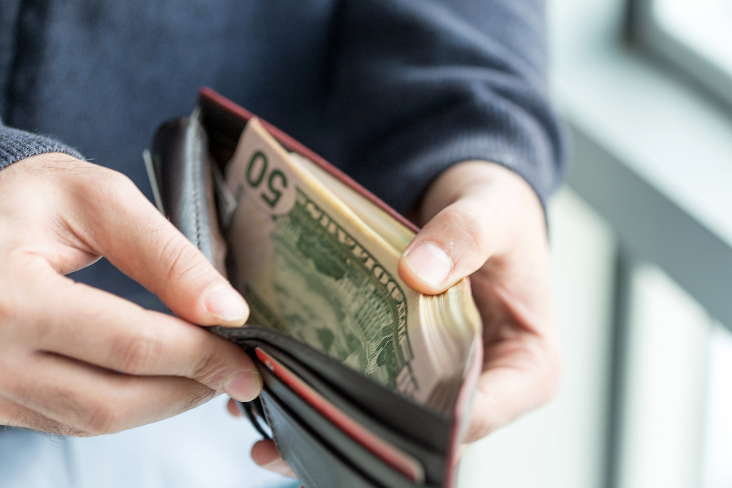 Man opening wallet with money