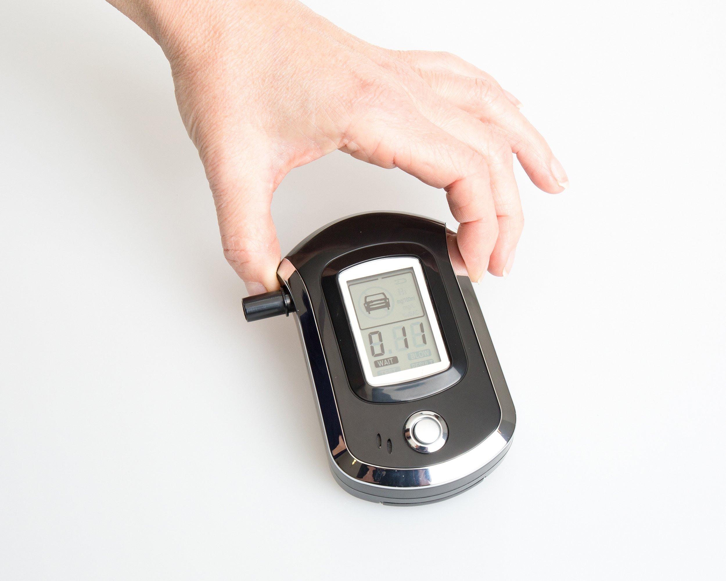 hands of woman holding a digital alcohol breathalyzer