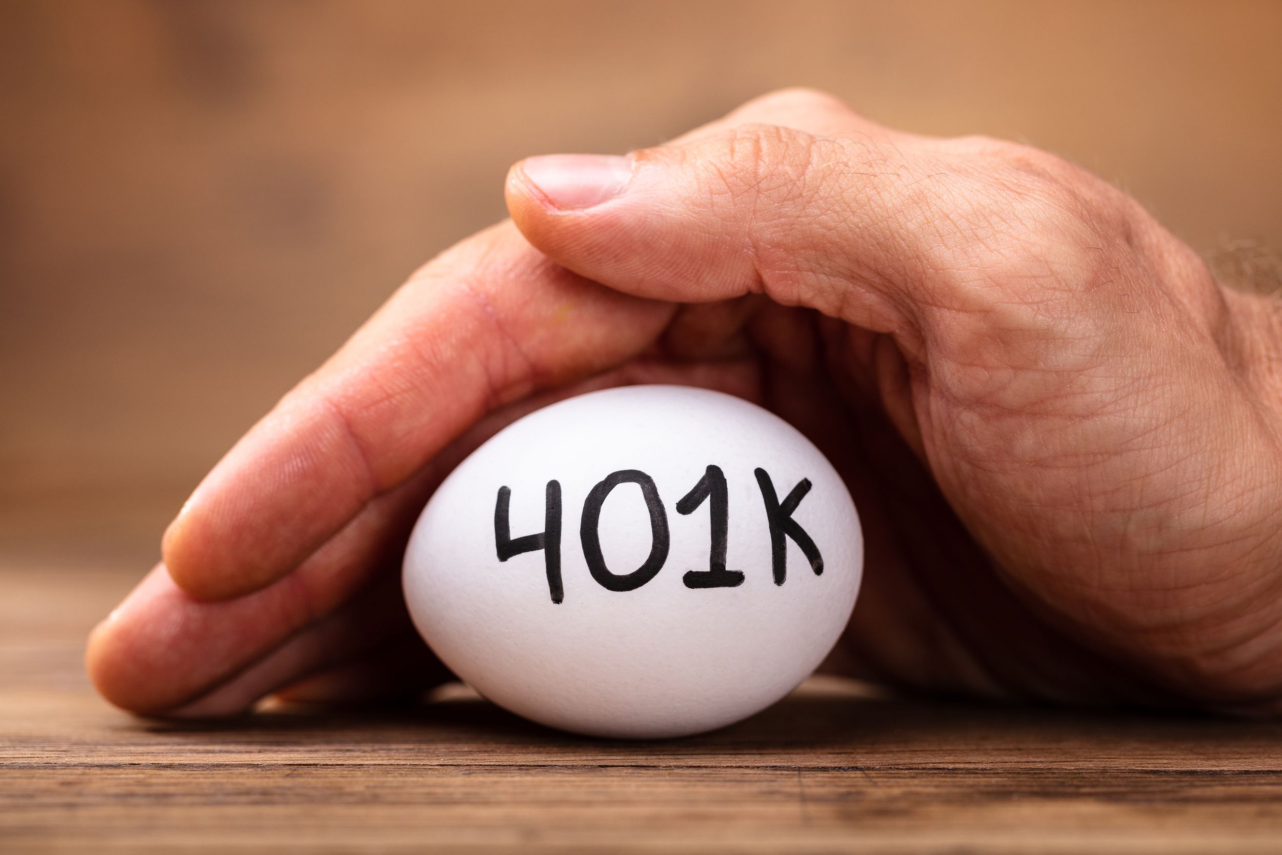 man protecting 401k white egg