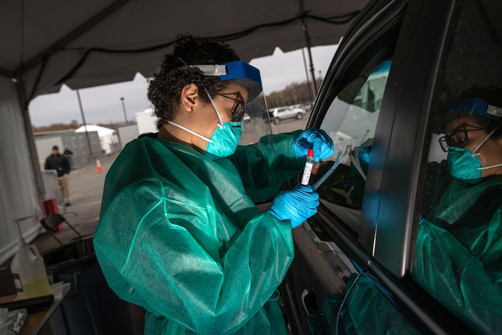 A health worker handles a swab test at a drive-thru testing center for COVID-19 at Lehman College on March 28, 2020 in the Bronx, New York City