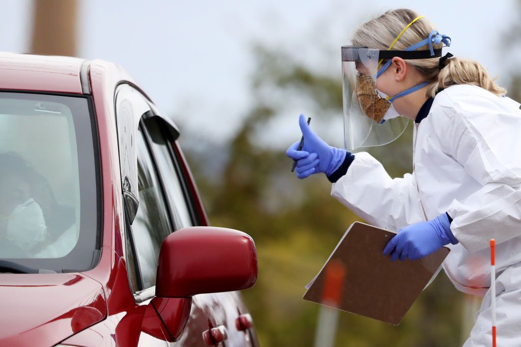 A medical professional works at a drive-thru COVID-19 testing site at Cambridge Health Alliance Somerville Hospital on April 28, 2020 in Somerville, Massachusetts