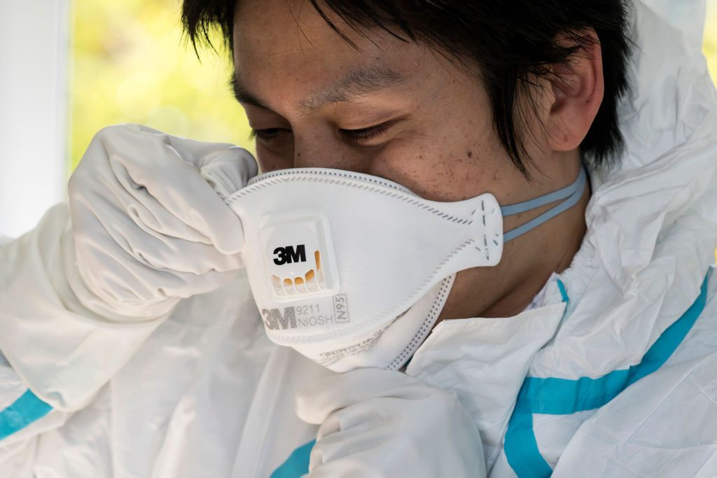 A staff member of the Yokosuka Medical Association wears a N95 mask before a demonstration collecting a swab sample to detect COVID-19 at a testing site in the Yokosuka Emergency Medical Center on April 23, 2020 in Yokosuka, Japan