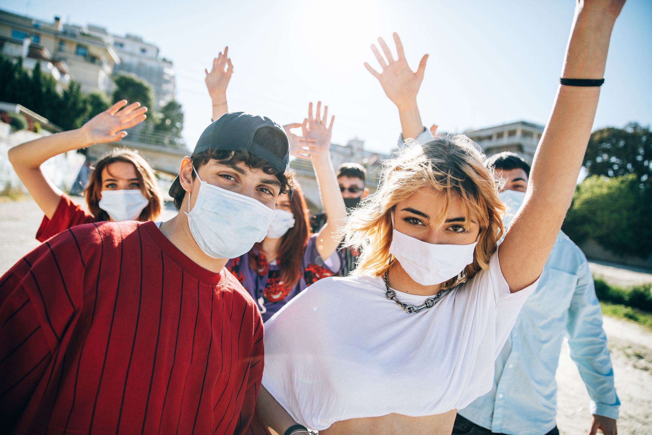 Group of mixed teenagers taking a selfie wearing face masks during COVID-19 outside during spring