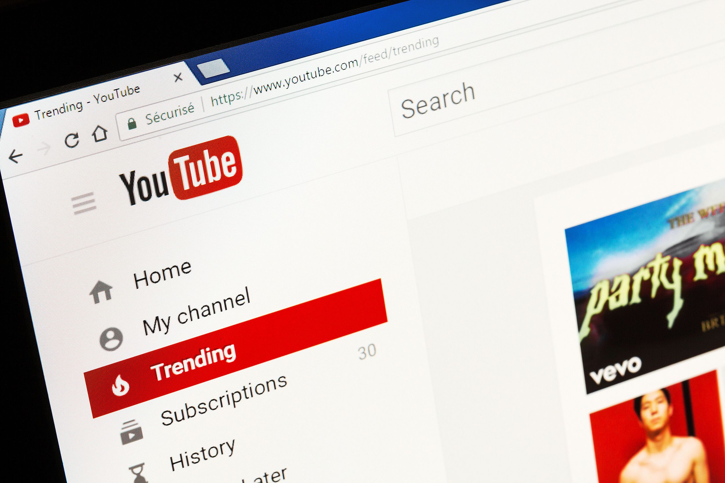 YouTube homepage on a browser of a laptop, slight diagonal, black background on the side left and top left