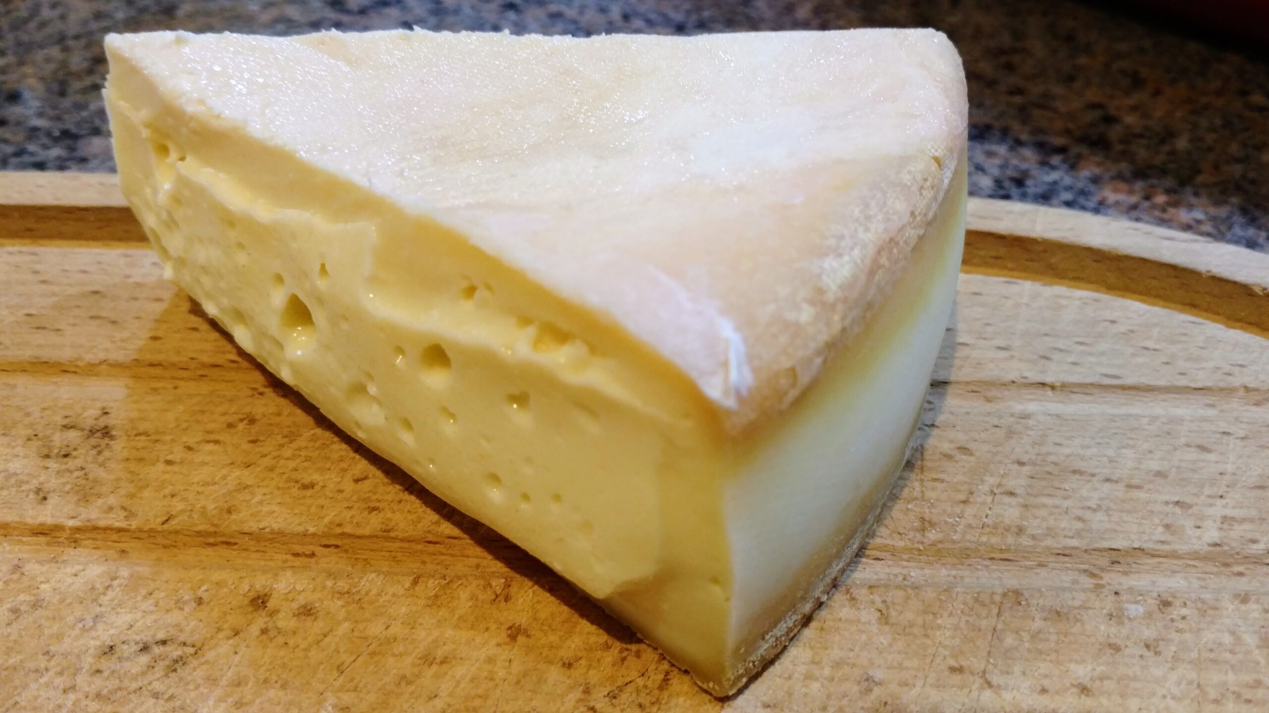 A slice from a wheel of Stinking Bishop cheese.