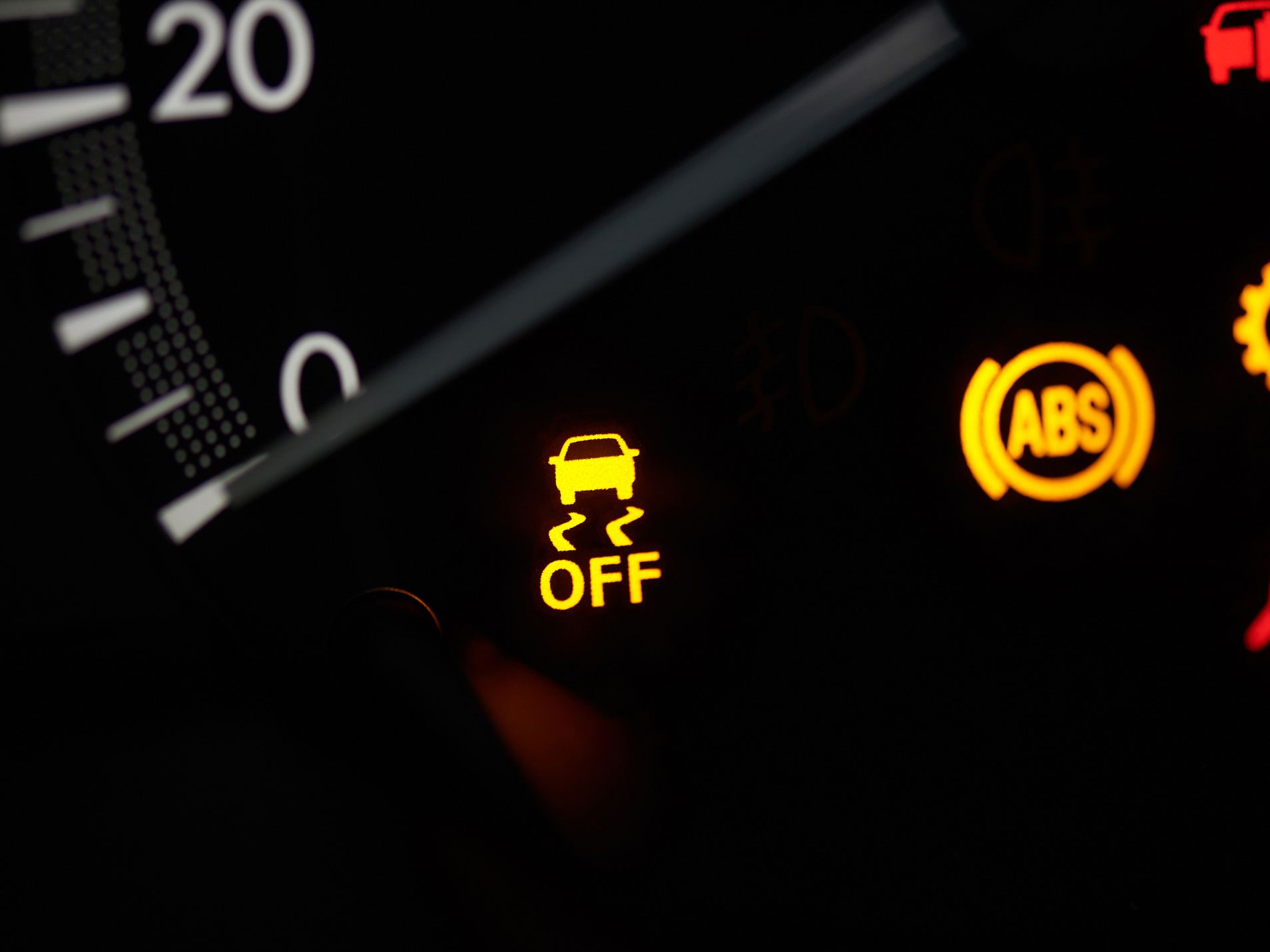 Close up of car speedometer with yellow warning sign