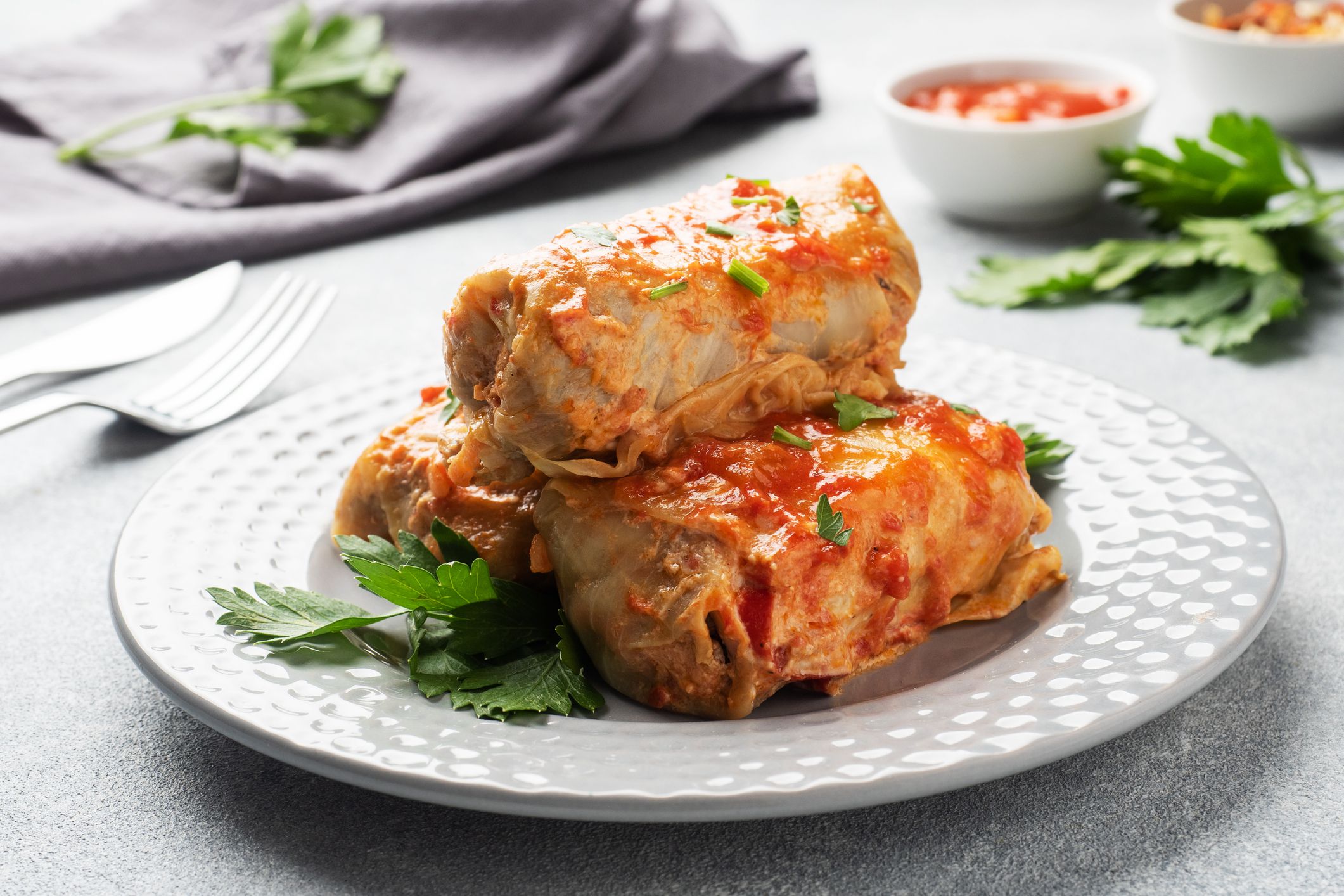 Cabbage rolls with beef, rice and vegetables on the plate. Stuffed cabbage leaves with meat. Gray concrete table.