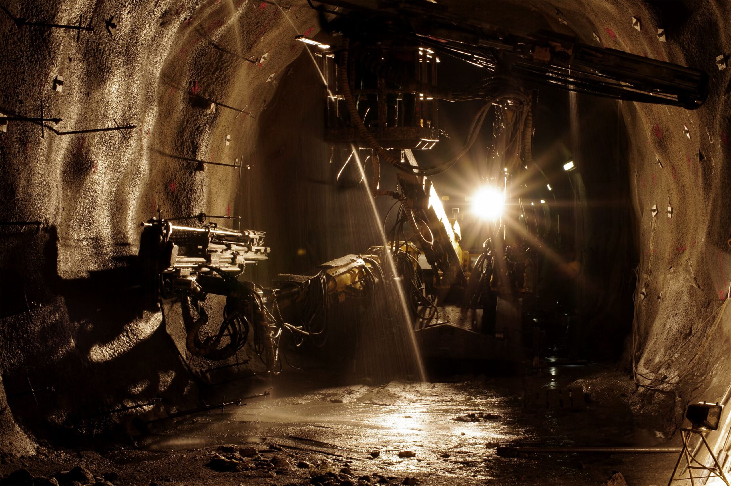 Heavy drilling machine drilling hydrogeological holes in underground environment (mine/tunnel). Brown color and some grain added to enhance the underground atmosphere.