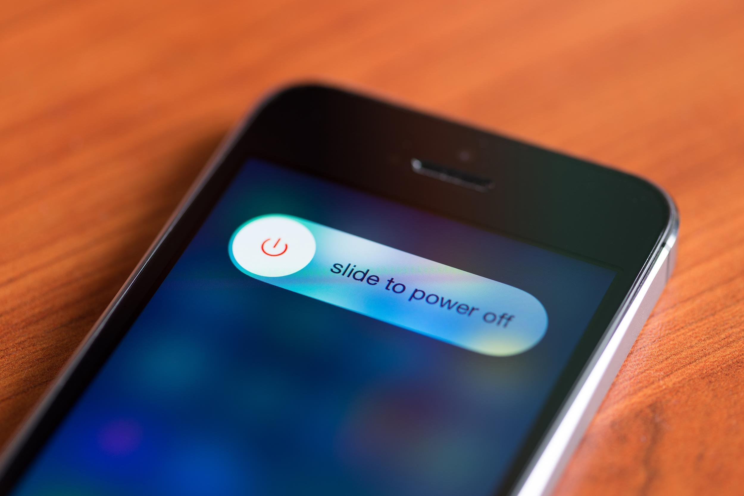 iPhone 5S with slide to power off option on a screen lying on a desk