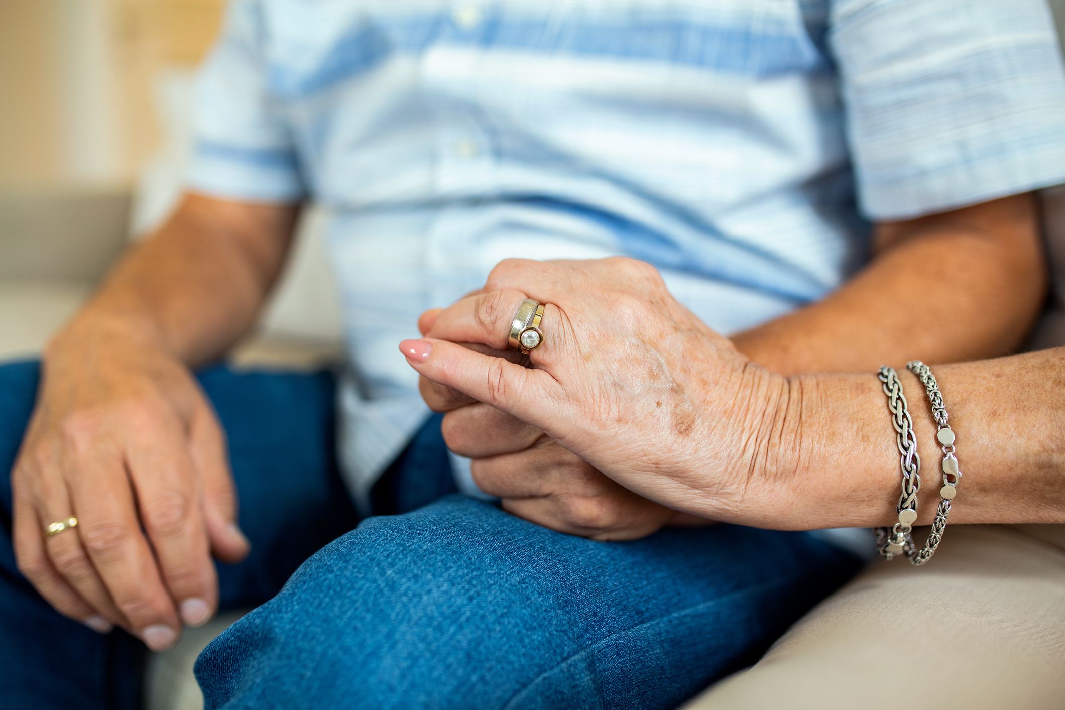 Closeup of a senior husband and wife holding hands in a loving manner
