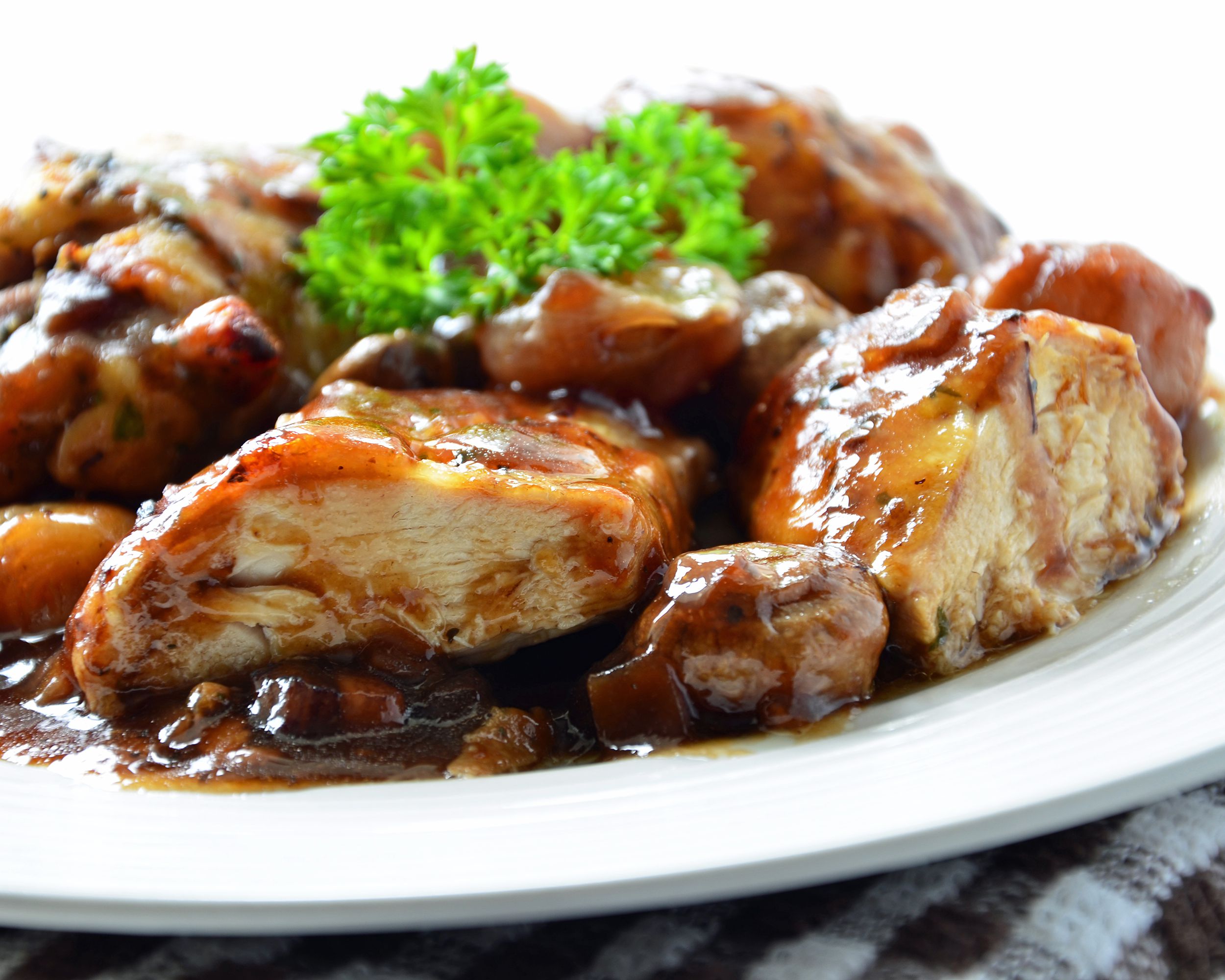 Coq au Vin on white plate garnished with fresh parsley