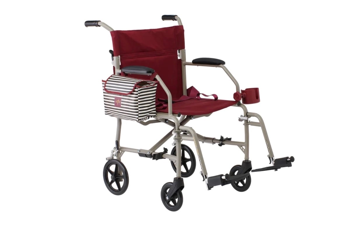 A lightweight, foldable wheelchair with a red seat and backrest, a striped bag on the armrest, and a red cup holder. Featuring four small wheels and footrests—perfect for those seeking Costco deals for seniors.