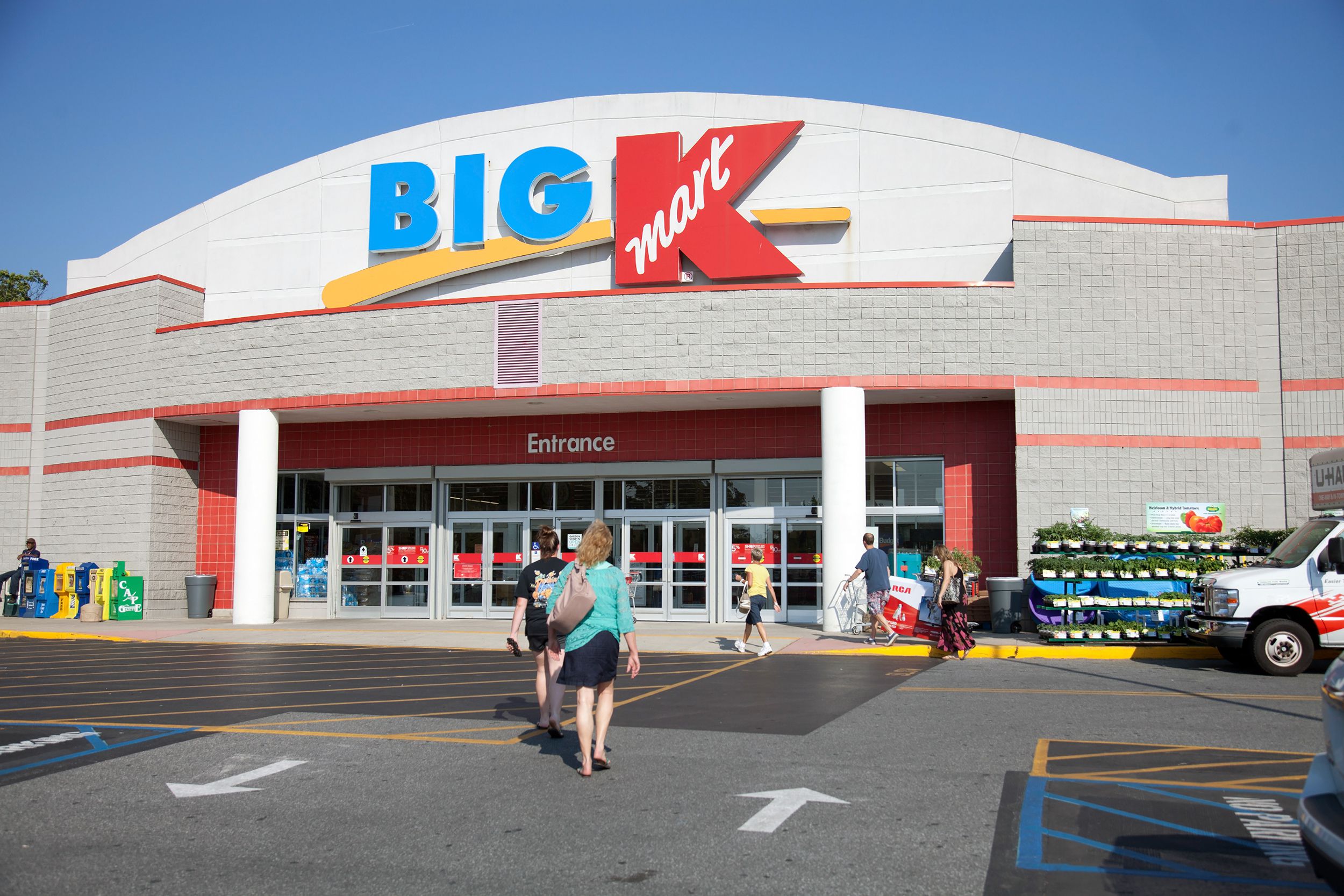 Front exterior of Big K-Mart store, Lewes, Delaware, people walking towards the entrance in the parking lot in the foreground, on a bright, sunny day