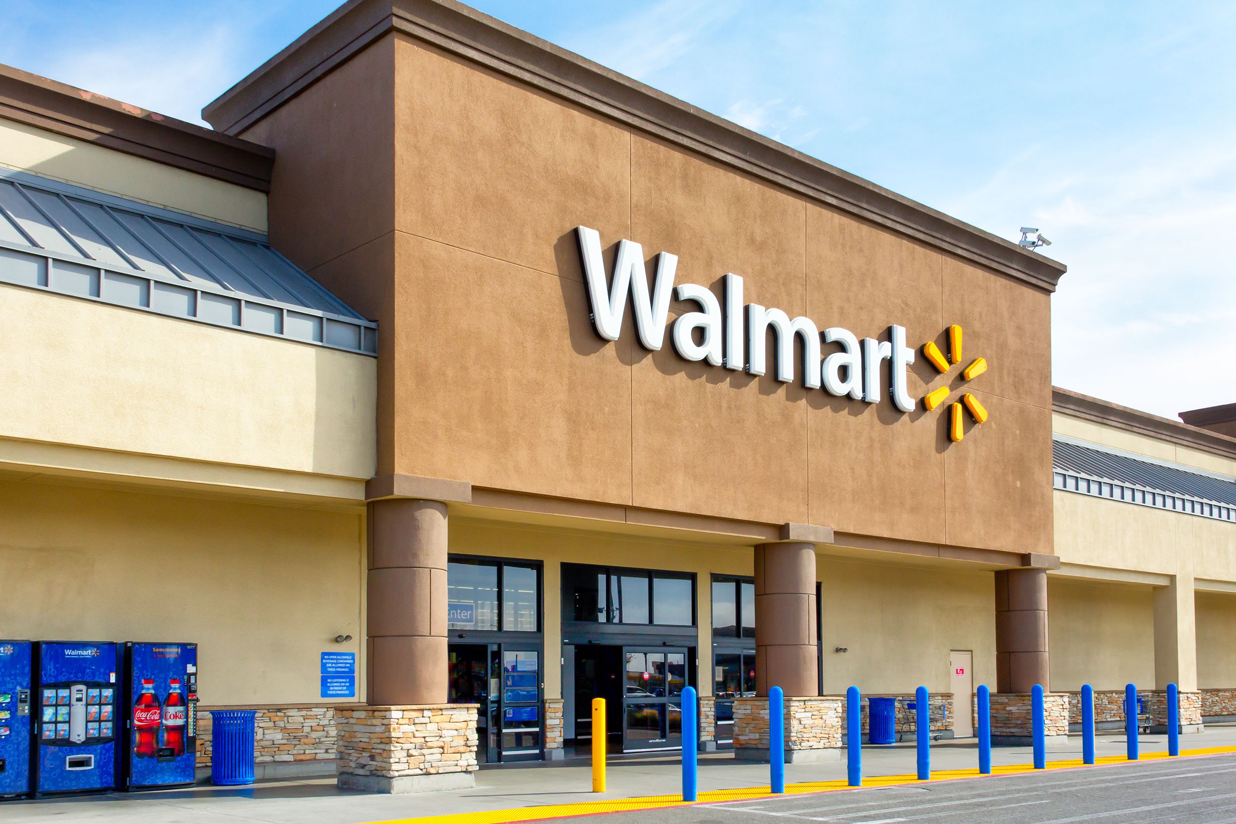 Front exterior of Walmart, Salinas, California, front doors, vending machines, and sidewalk, on a sunny day
