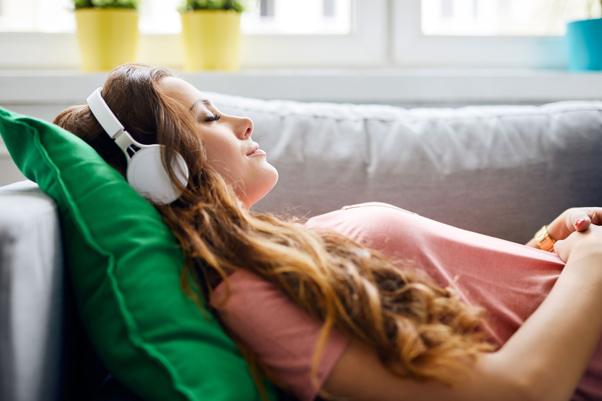 Woman napping on the couch wearing headphones