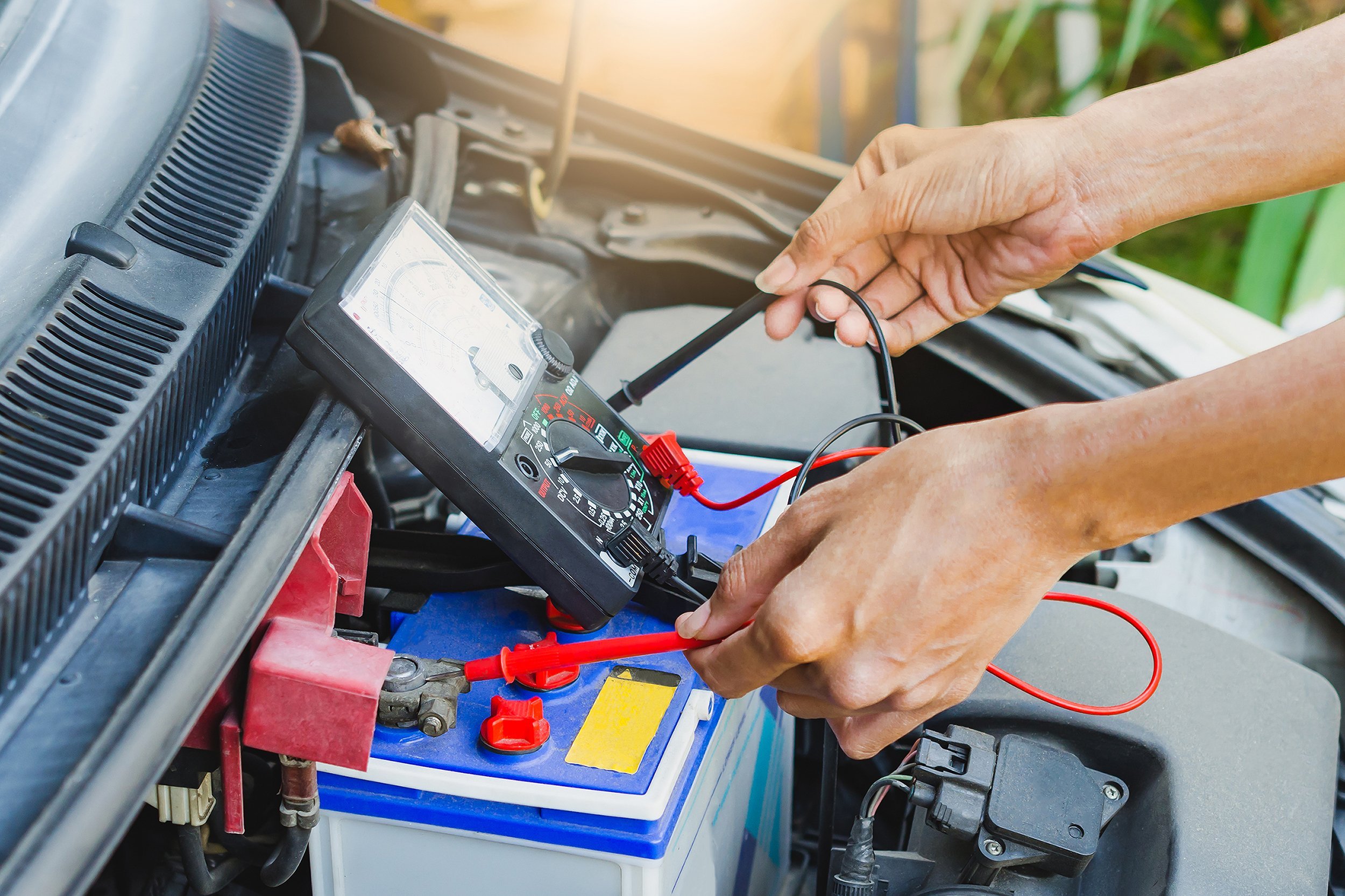 man checking power of battery by meter