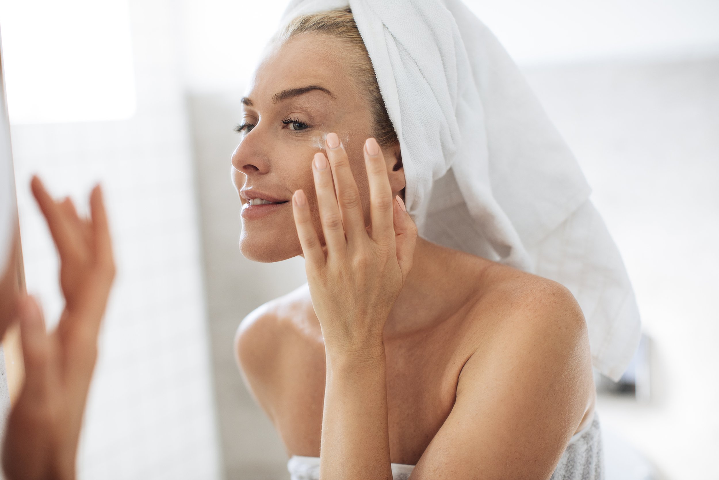woman applying creme on face