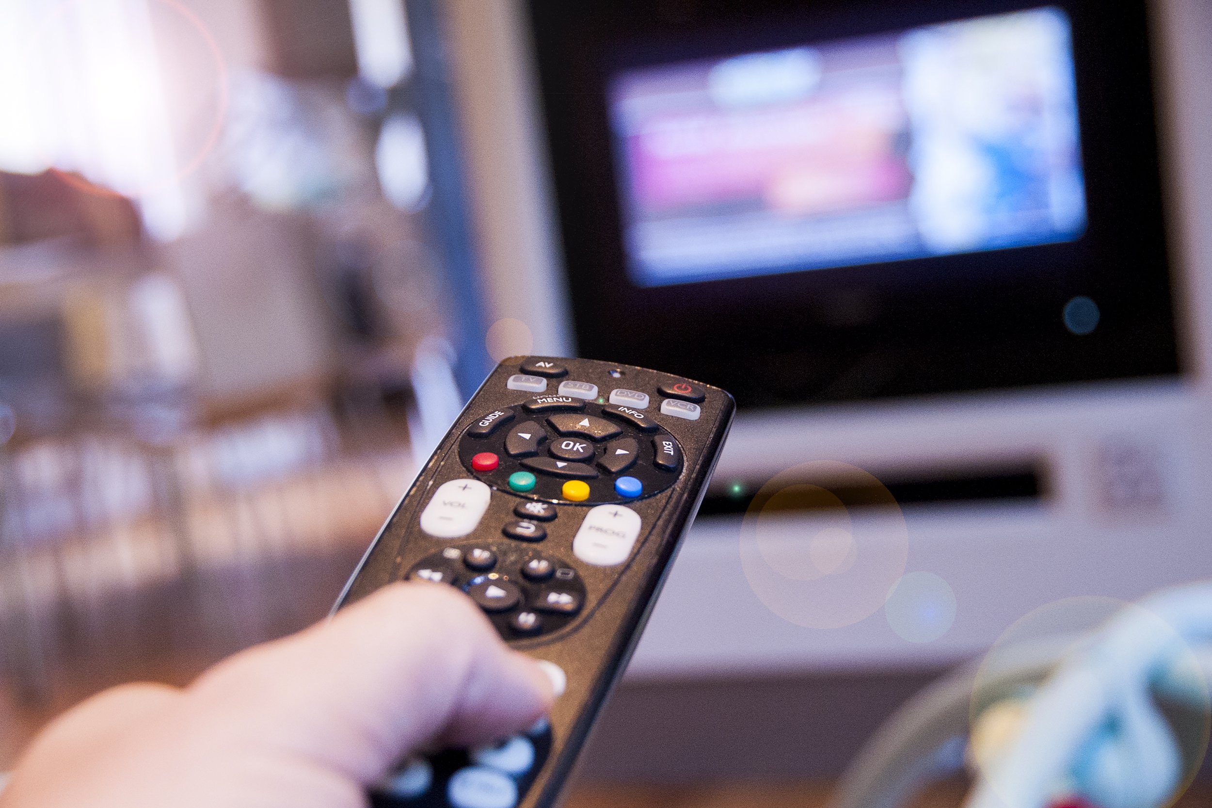 Close up of remote control in front of television