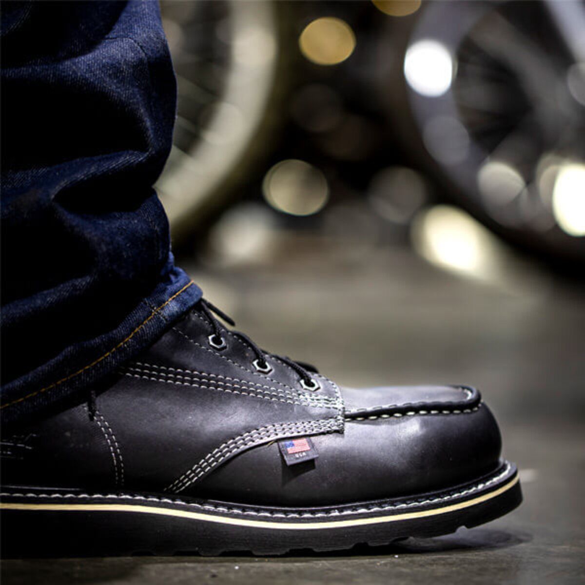 Closeup of Thorogood black boot with industrial background