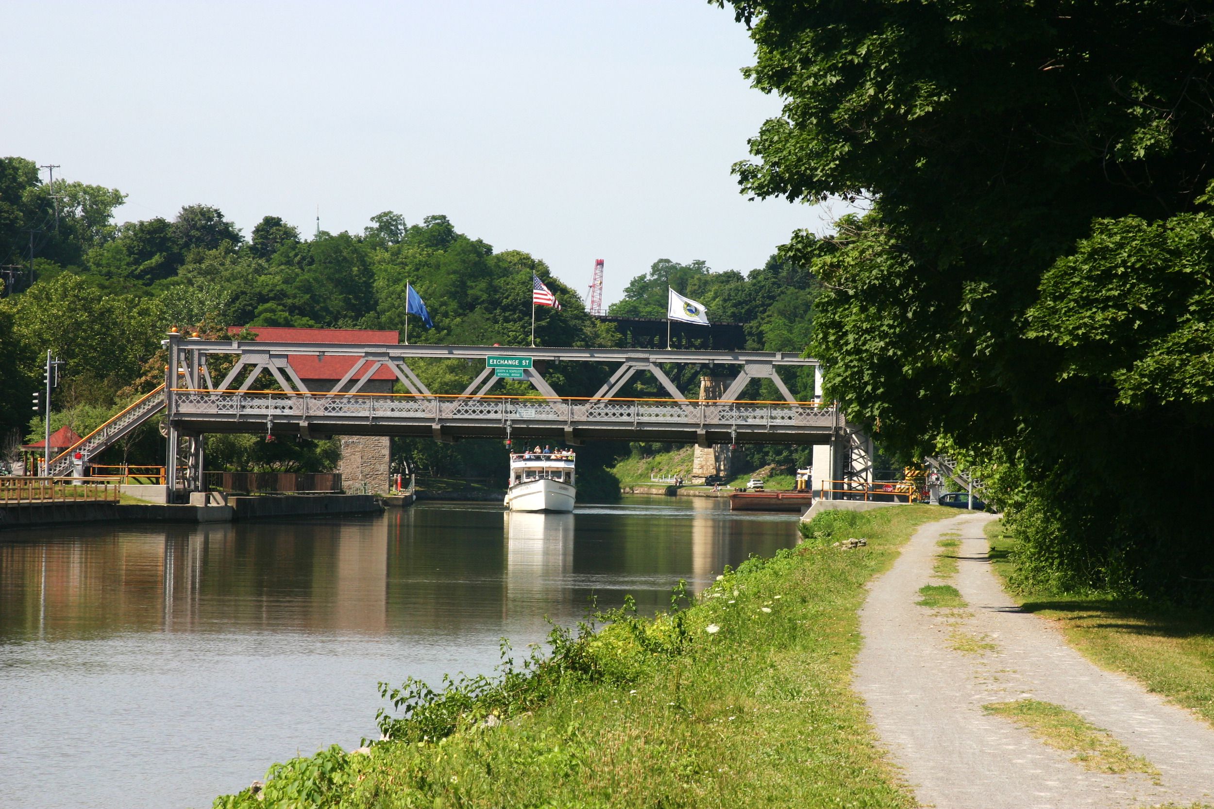 Drawbridge at Exchange Street along the Erie Canal, New York, bike path on the right foreground going into the distance, on a cloudy day in summer
