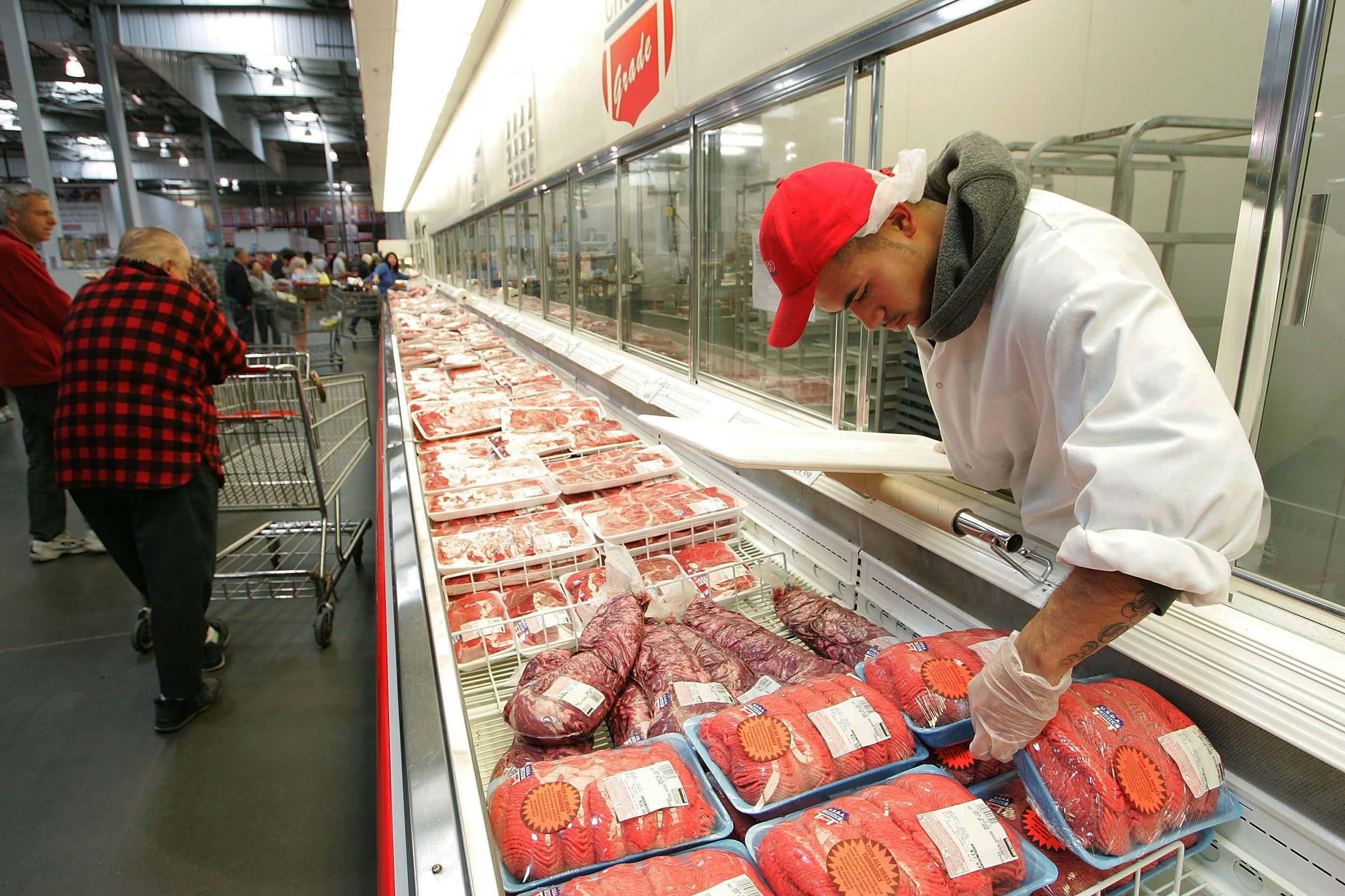 Costco worker arranges meat in a display at a Costco Warehouse store March, 2, 2006 in Richmond, California