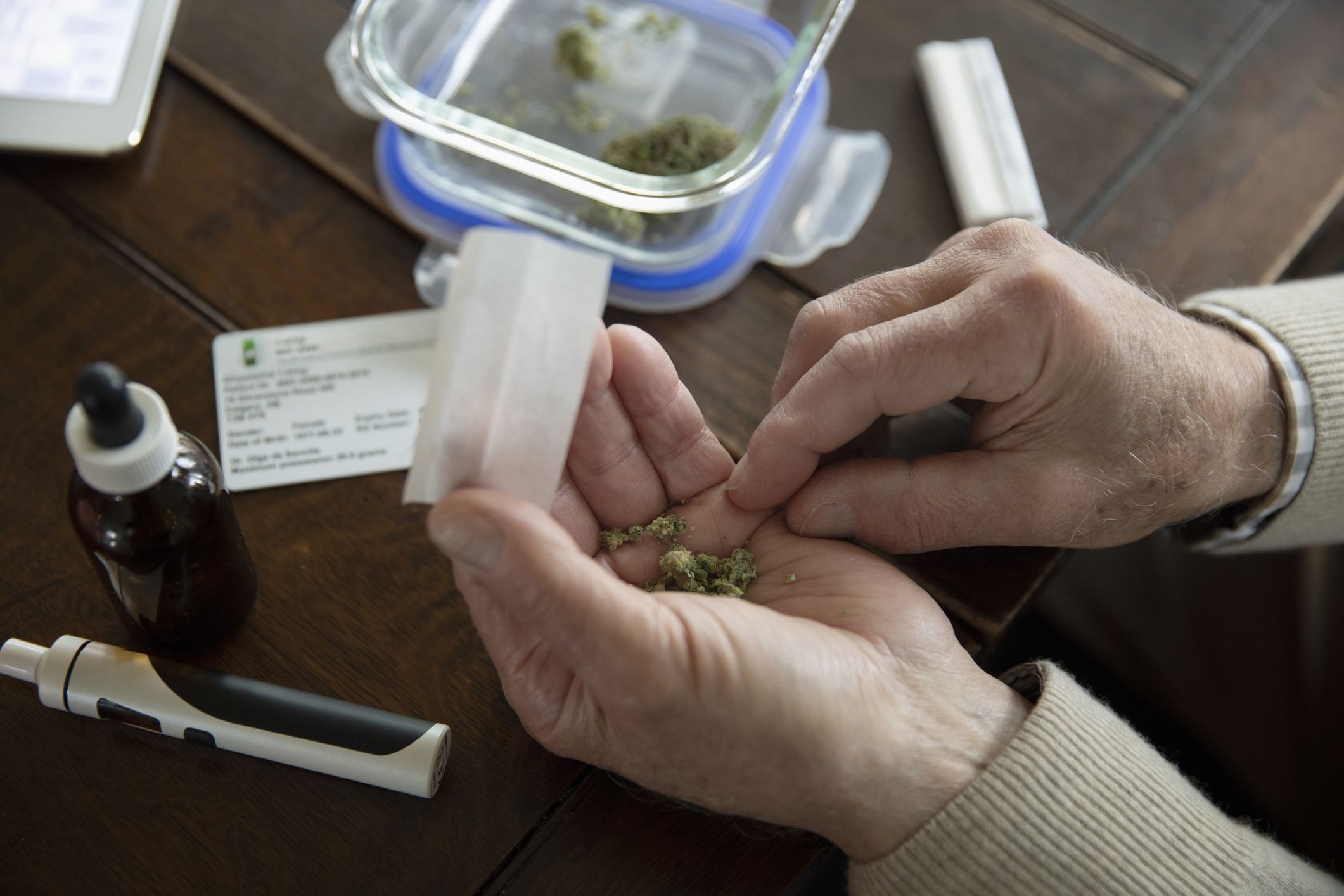 close-up of senior man rolling joint