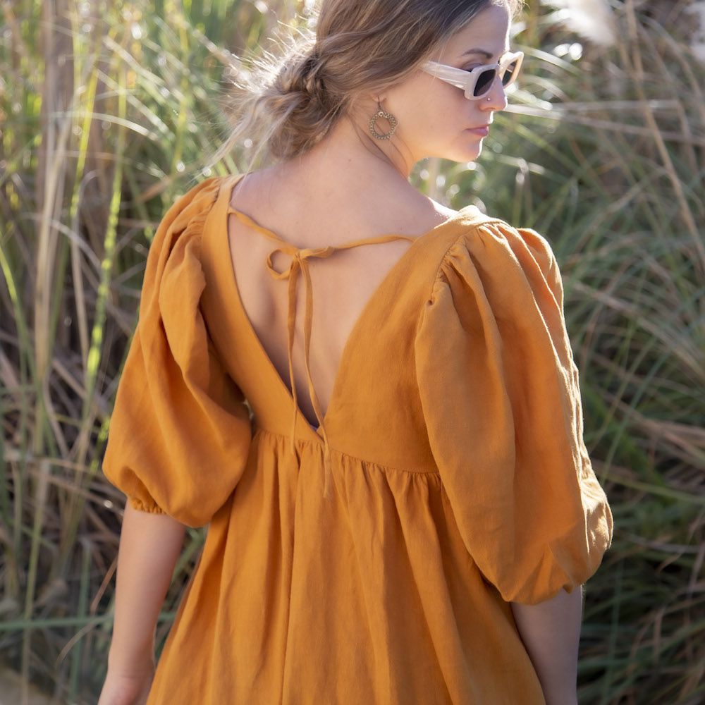 Woman posing in Ruffle Midi Dress in Saffron by Hackwith Design House