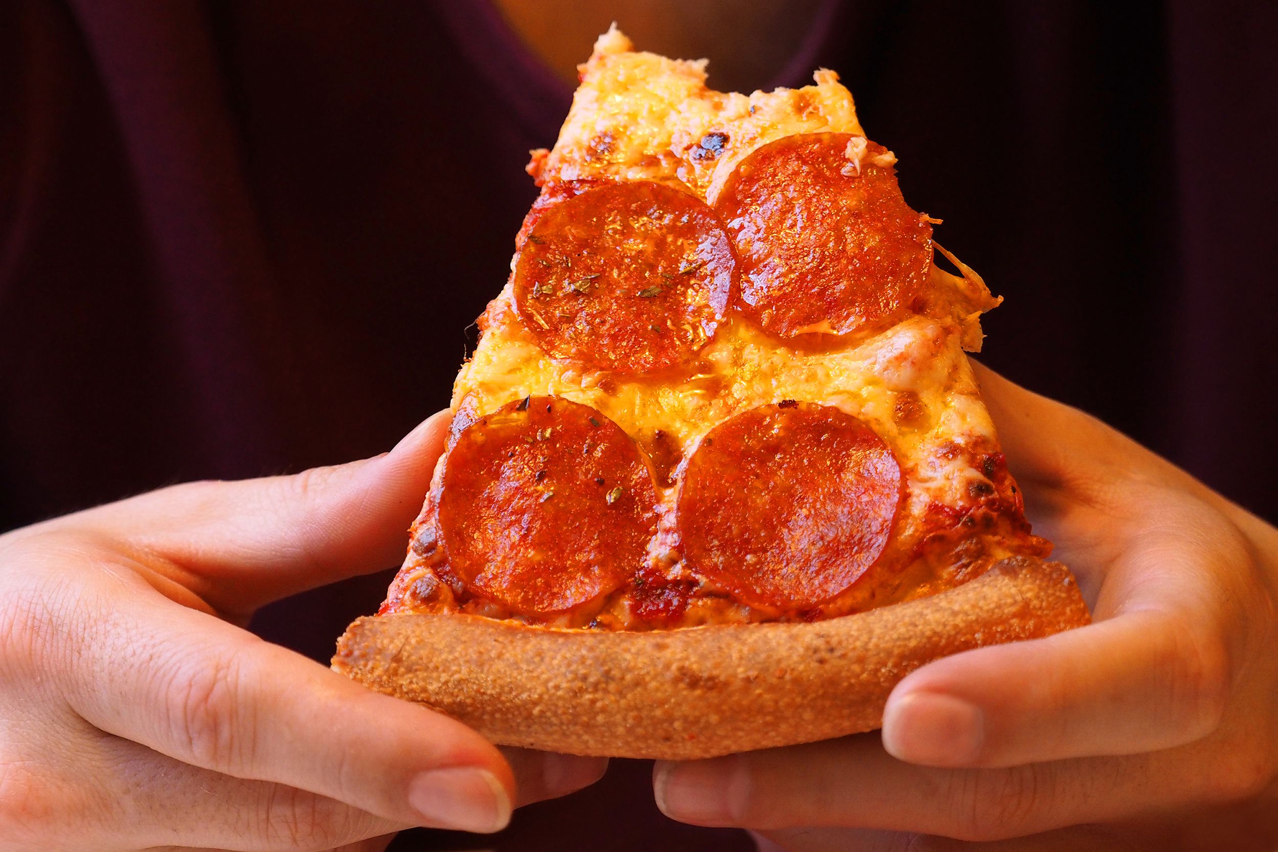 Closeup of pizza slice with a bite taken out