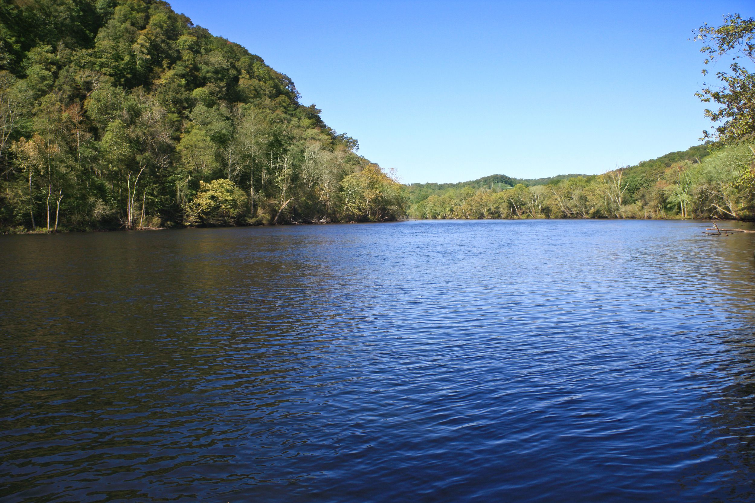 Norris Reservoir at Norris Dam State Park, Tennessee, lake in the foreground with trees and hills in the background, on a sunny day during summer